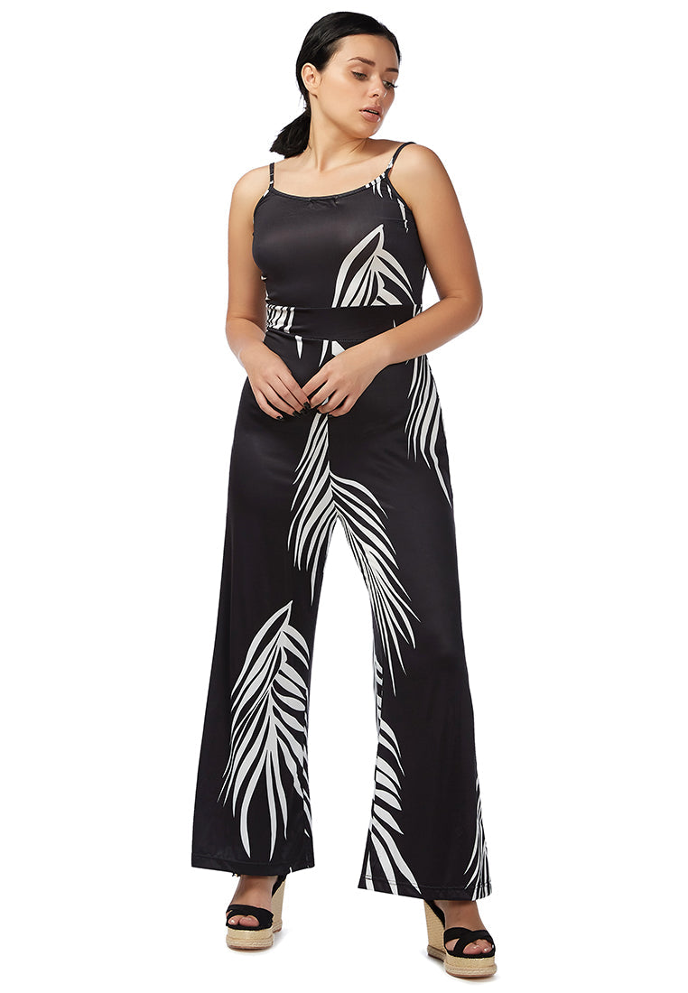 A stylish spaghetti strap jumpsuit featuring a white palm leaves print, perfect for beach outings and summer events.