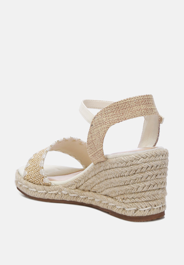 A pair of stylish Lucas Raffia Wedge Heel Espadrilles featuring a raffia upper, classic wedge heel, and ankle strap detail, perfect for summer outings.