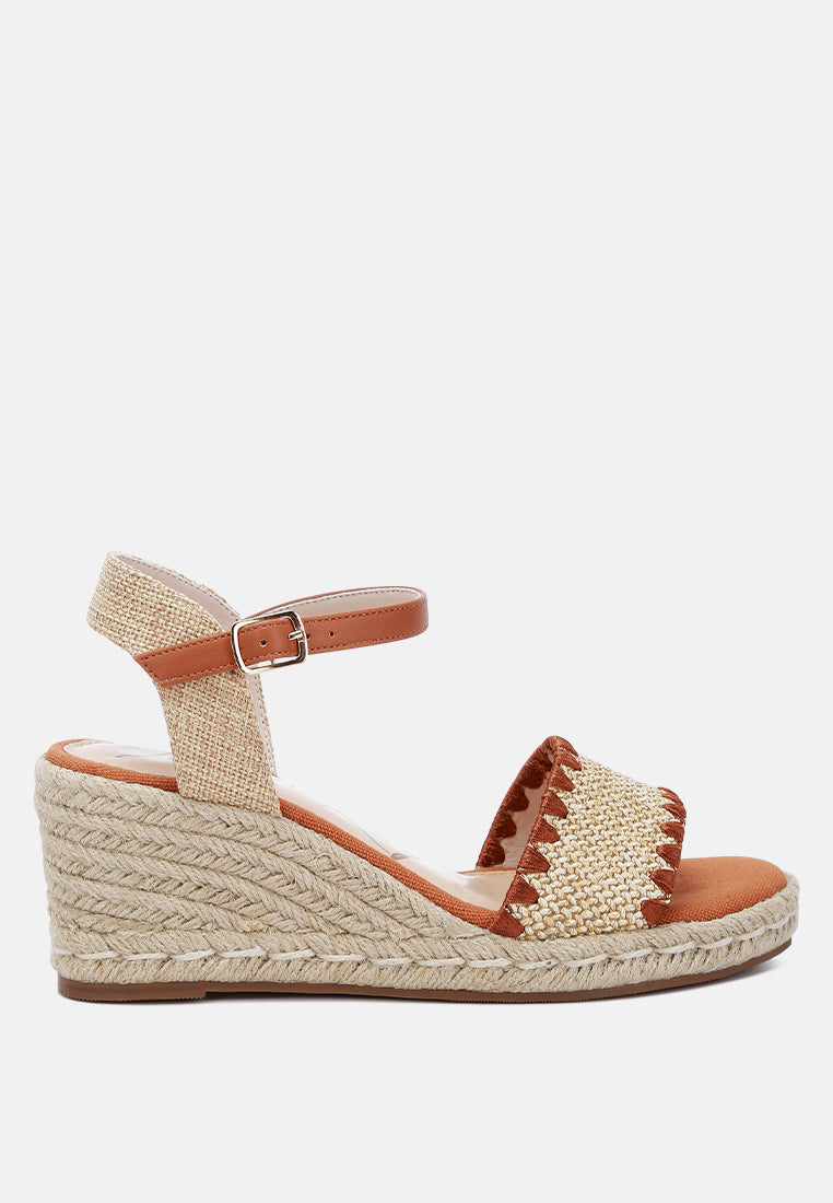 A pair of stylish Lucas Raffia Wedge Heel Espadrilles featuring a raffia upper, classic wedge heel, and ankle strap detail, perfect for summer outings.