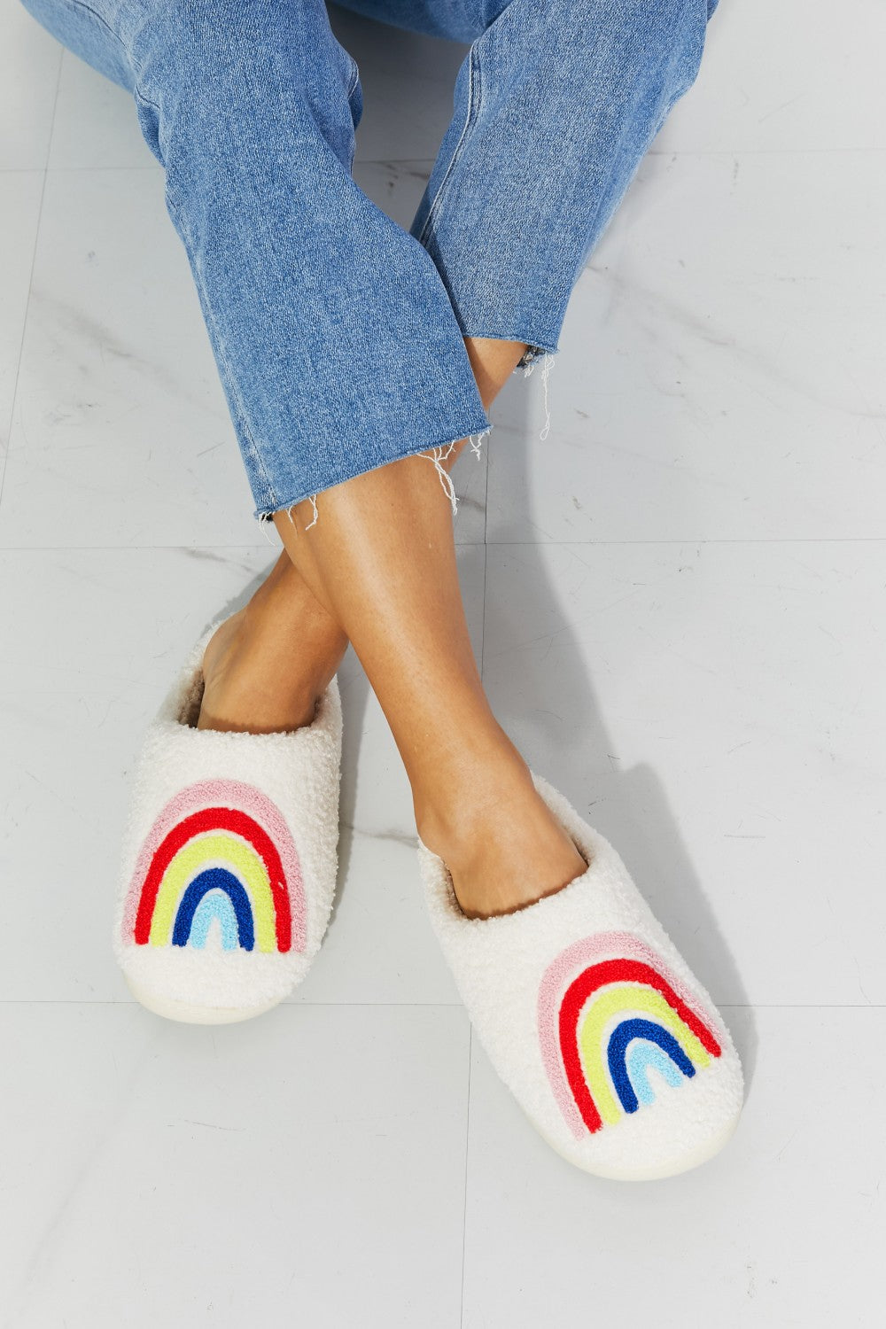 MMShoes Rainbow Plush Slipper featuring a colorful rainbow graphic design with soft faux fur material and a durable rubber sole.