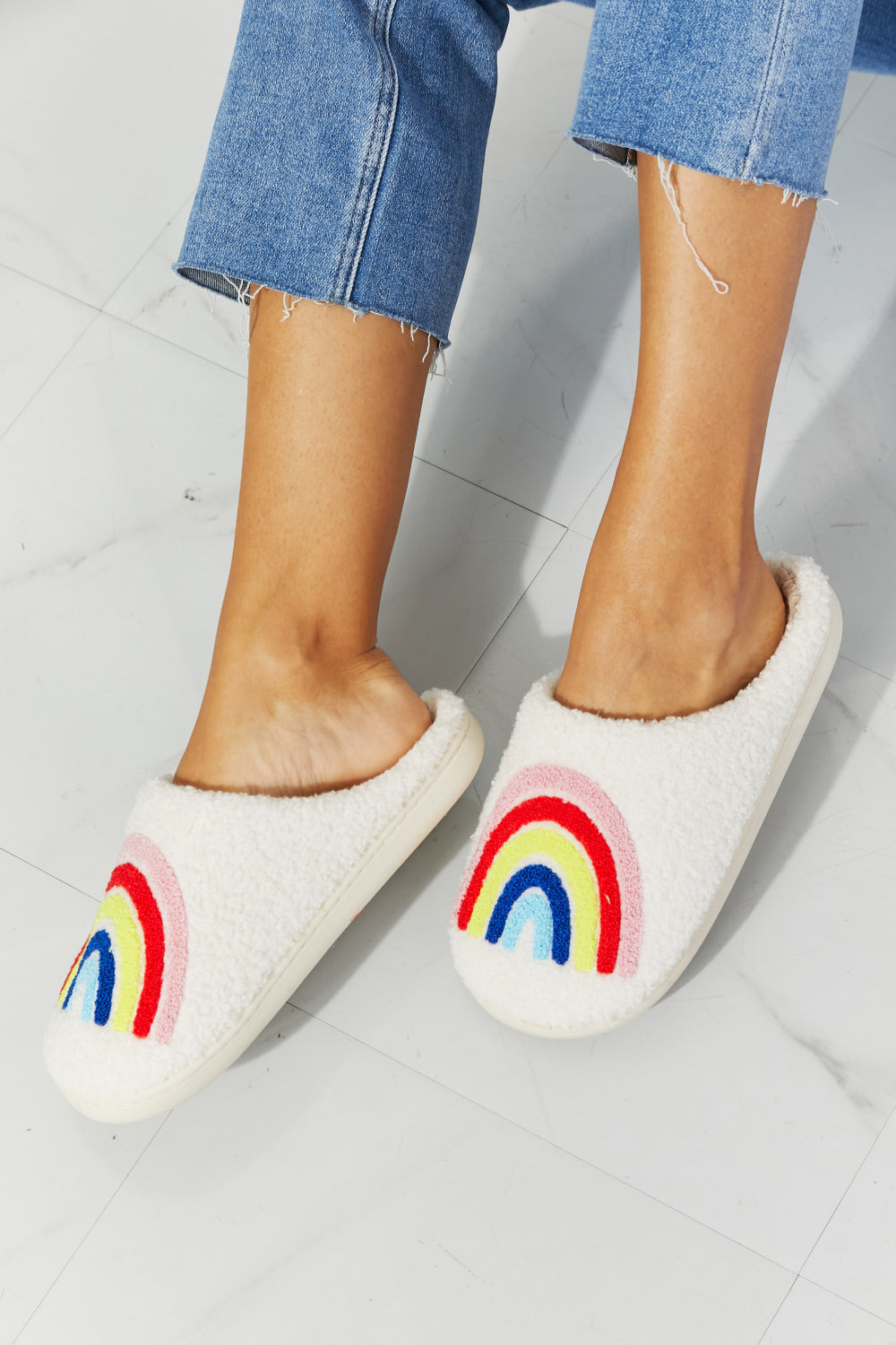 MMShoes Rainbow Plush Slipper featuring a colorful rainbow graphic design with soft faux fur material and a durable rubber sole.