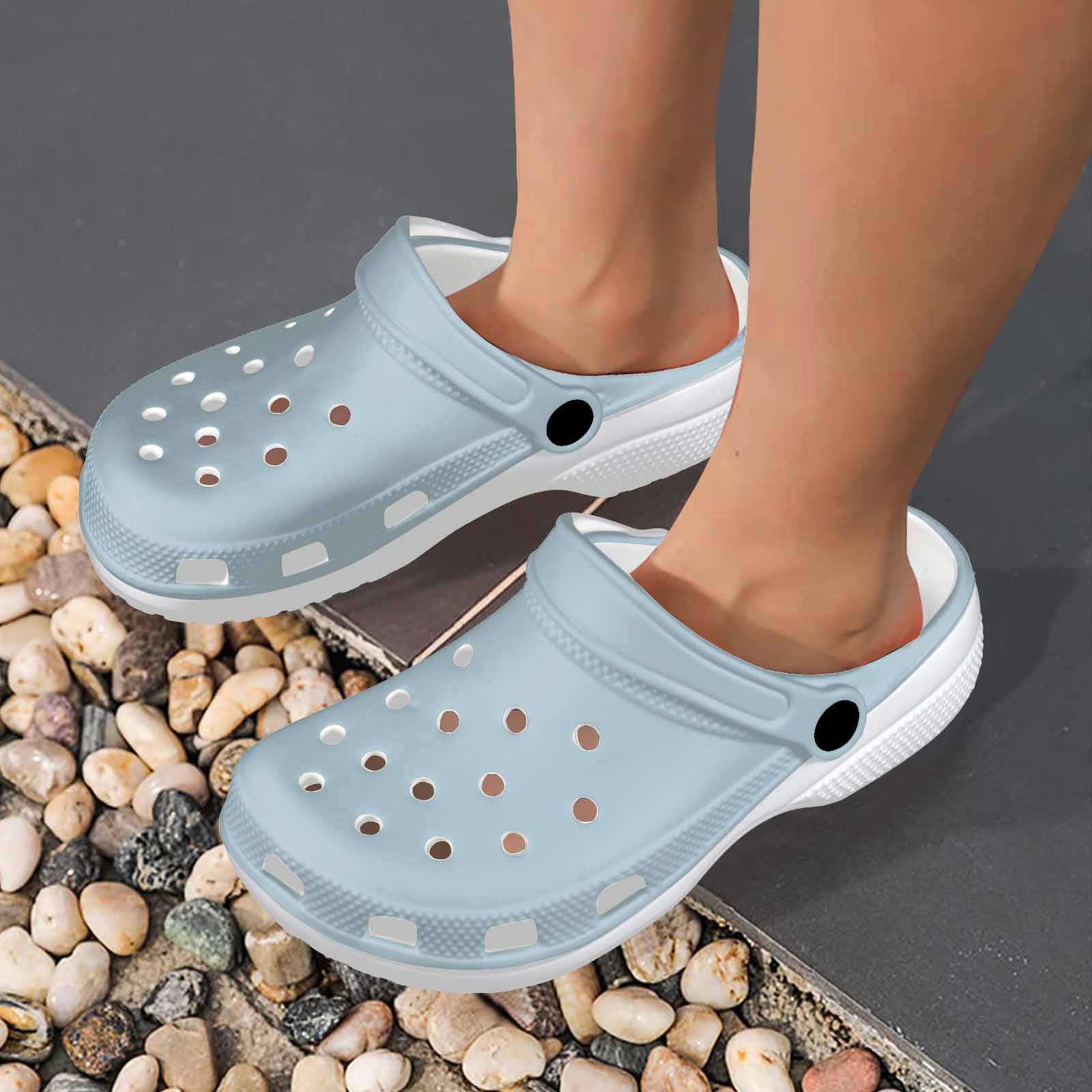 Pastel blue adult clogs made from lightweight EVA material, featuring ventilation ports and pivoting heel straps for a secure fit.