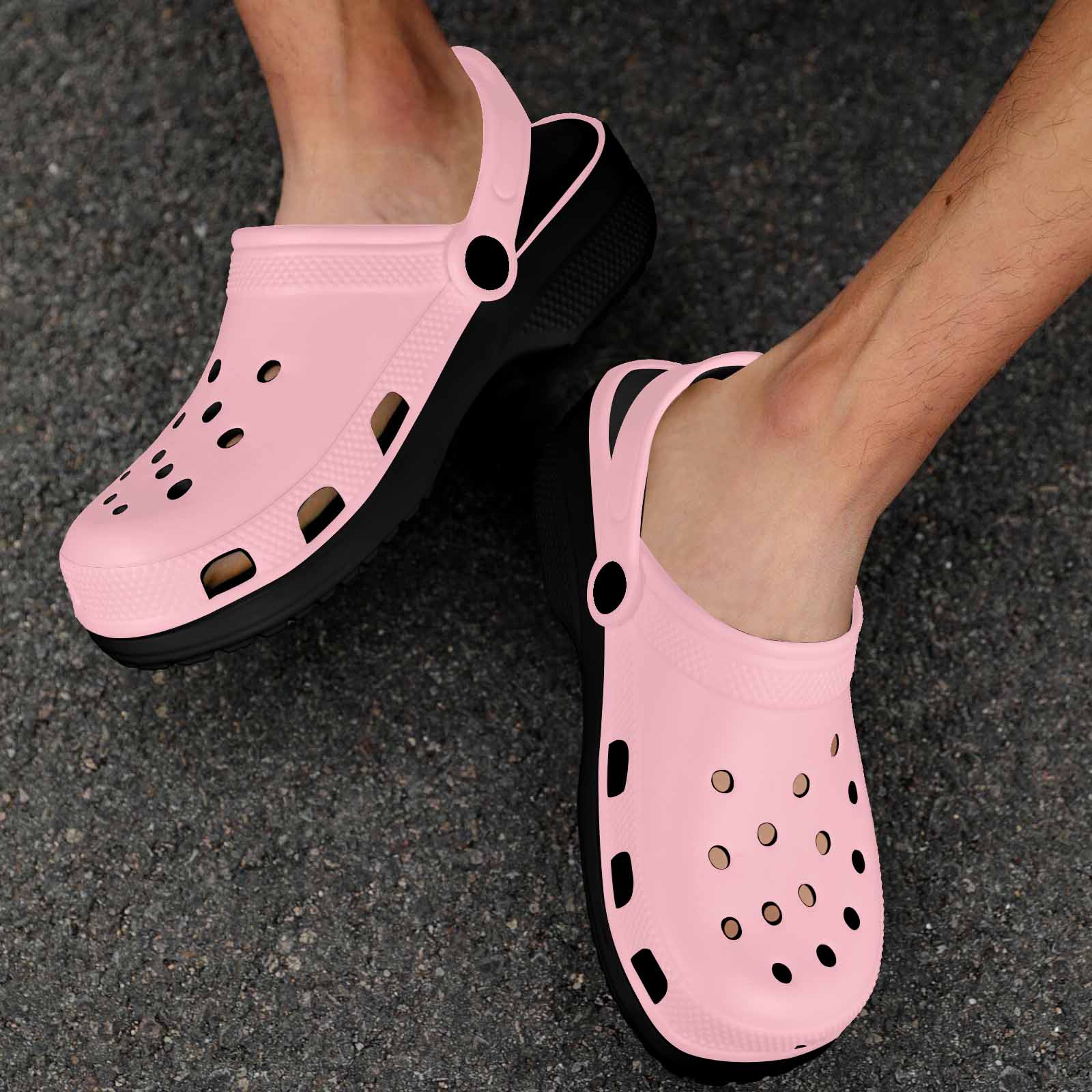 A pair of pink adult clogs made from lightweight EVA material, featuring ventilation ports and pivoting heel straps for a secure fit.