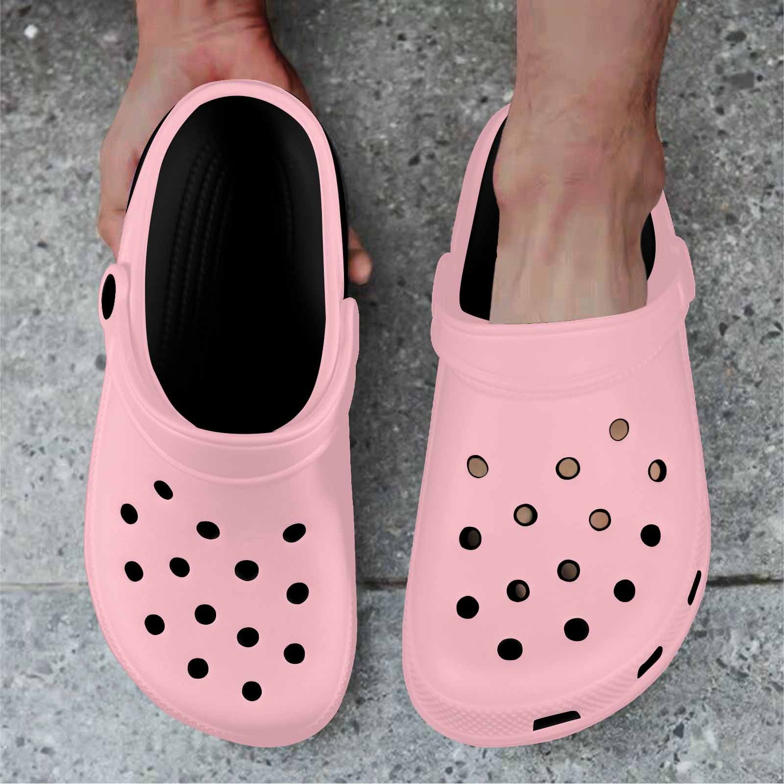 A pair of pink adult clogs made from lightweight EVA material, featuring ventilation ports and pivoting heel straps for a secure fit.