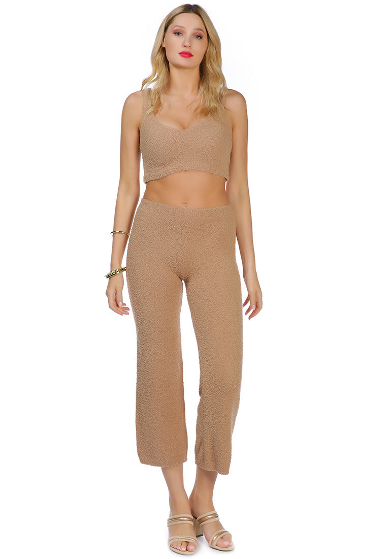 A pair of solid high waist wide leg trousers made from breathable cotton, featuring an elasticated waistband and ankle-length cut.