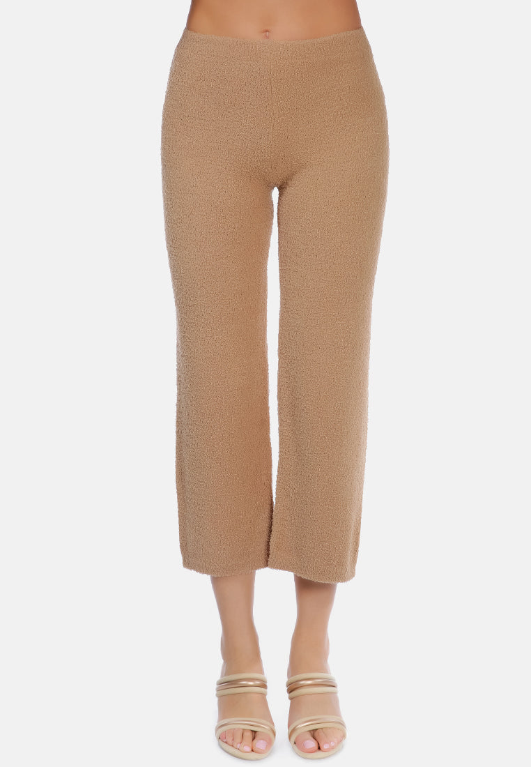 A pair of solid high waist wide leg trousers made from breathable cotton, featuring an elasticated waistband and ankle-length cut.