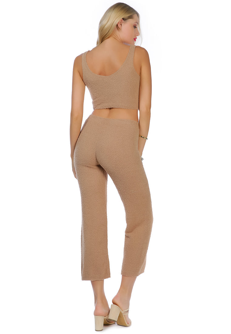 A pair of solid high waist wide leg trousers made from breathable cotton, featuring an elasticated waistband and ankle-length cut.