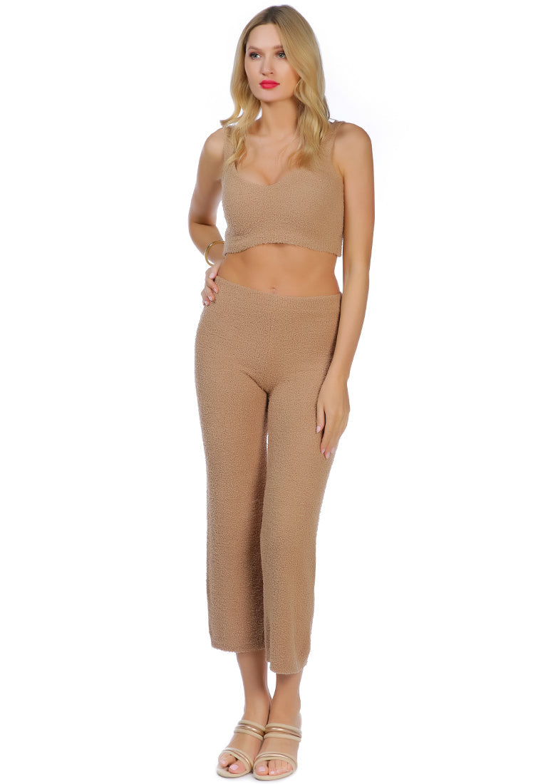 A pair of solid high waist wide leg trousers made from breathable cotton, featuring an elasticated waistband and ankle-length cut.