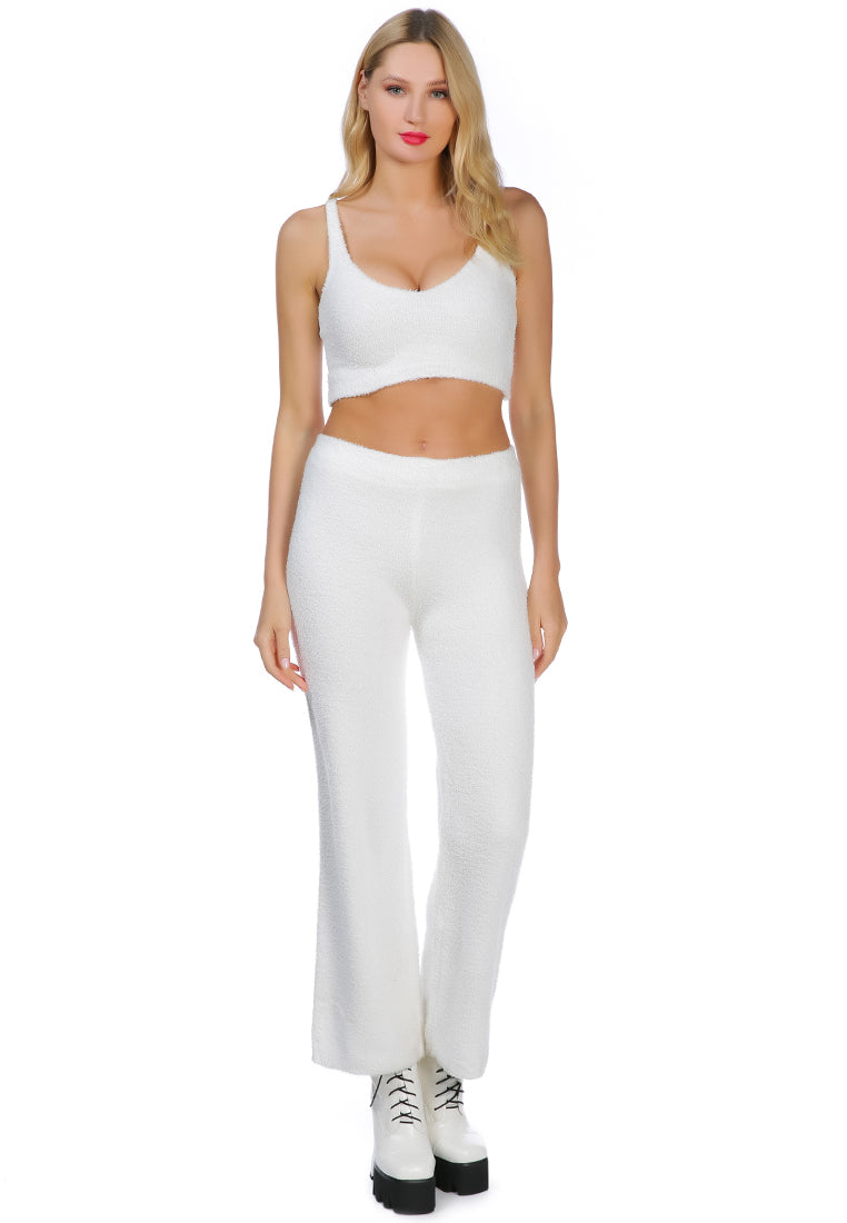 A pair of solid high waist wide leg trousers made from breathable cotton, featuring an elasticated waistband and ankle-length cut.