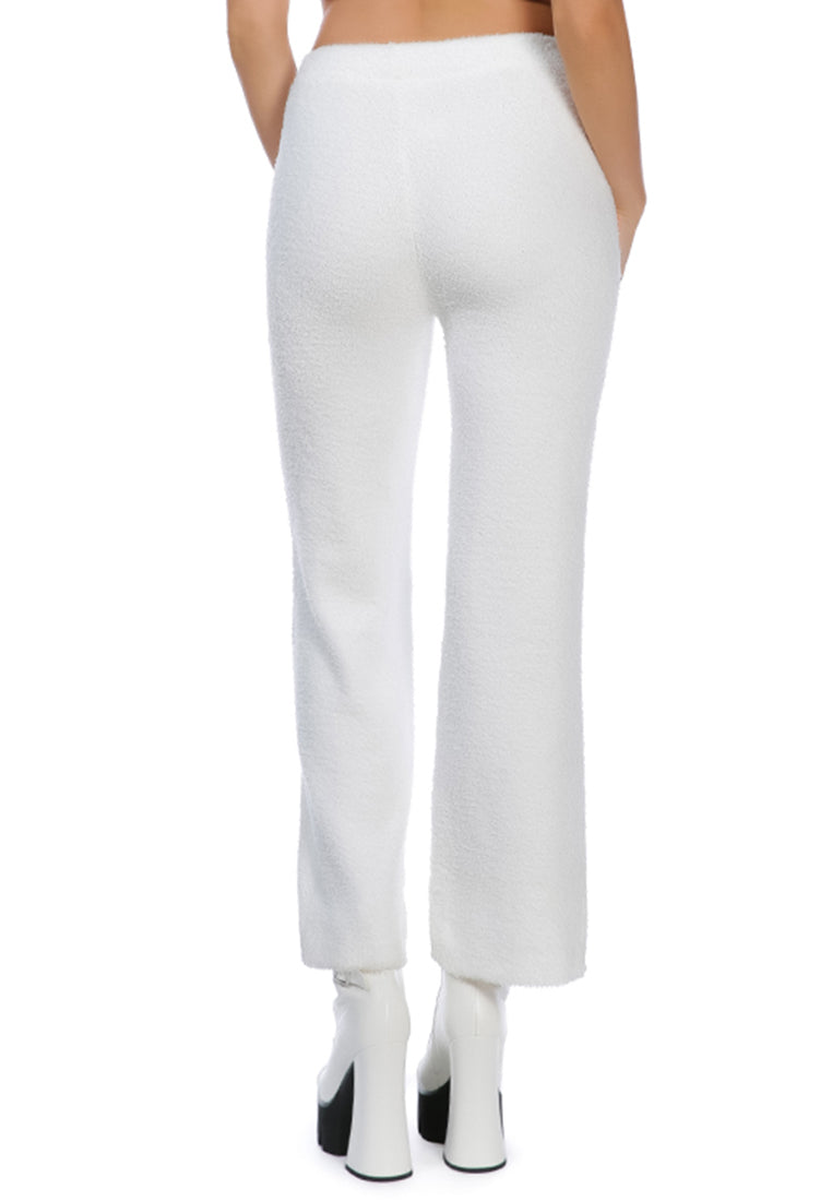 A pair of solid high waist wide leg trousers made from breathable cotton, featuring an elasticated waistband and ankle-length cut.