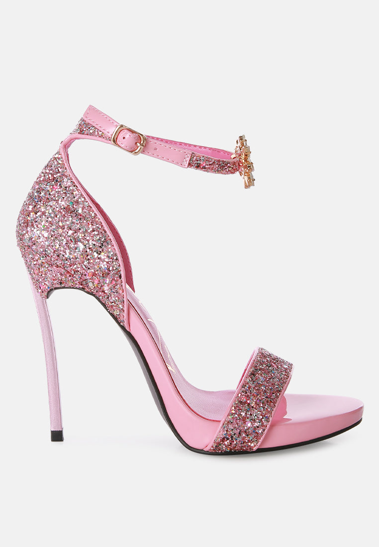 A pair of glamorous Straight Fire High Heel Glitter Stilettos featuring a glittery finish, floral jewel brooch, and a secure ankle strap.