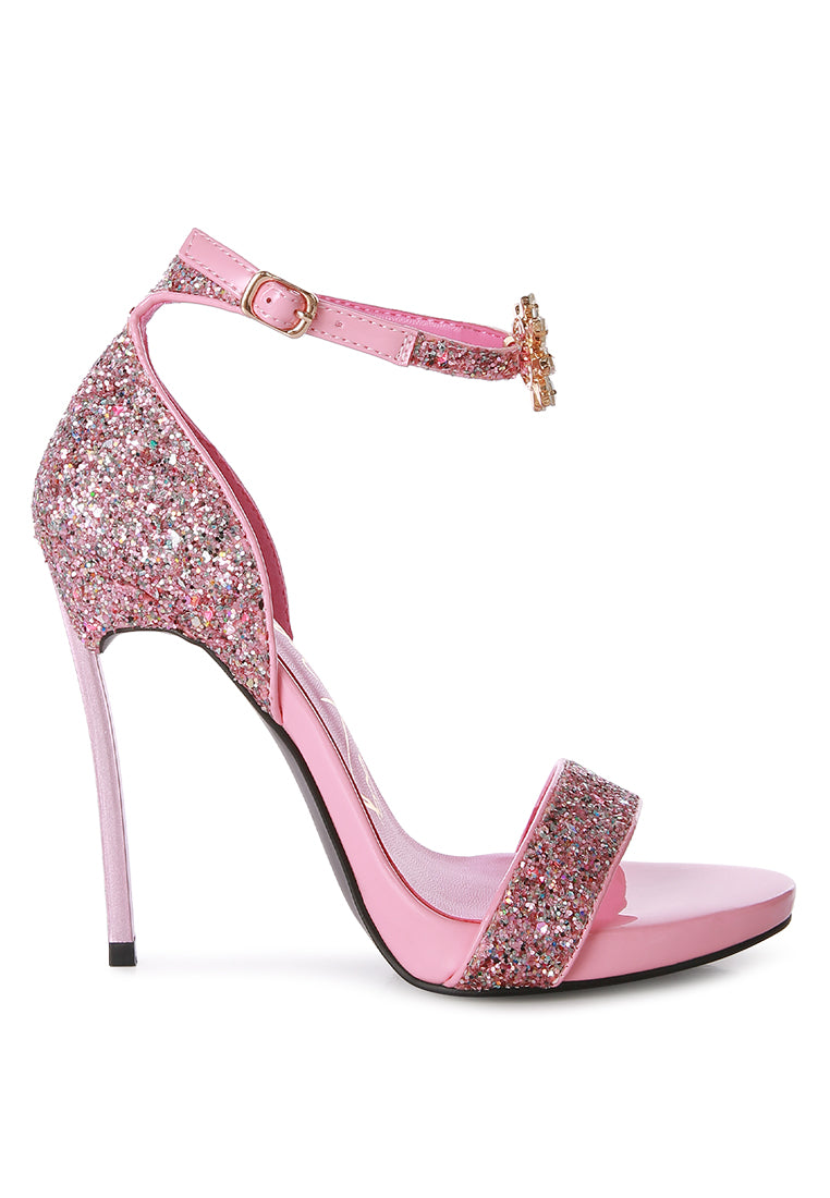 A pair of glamorous Straight Fire High Heel Glitter Stilettos featuring a glittery finish, floral jewel brooch, and a secure ankle strap.