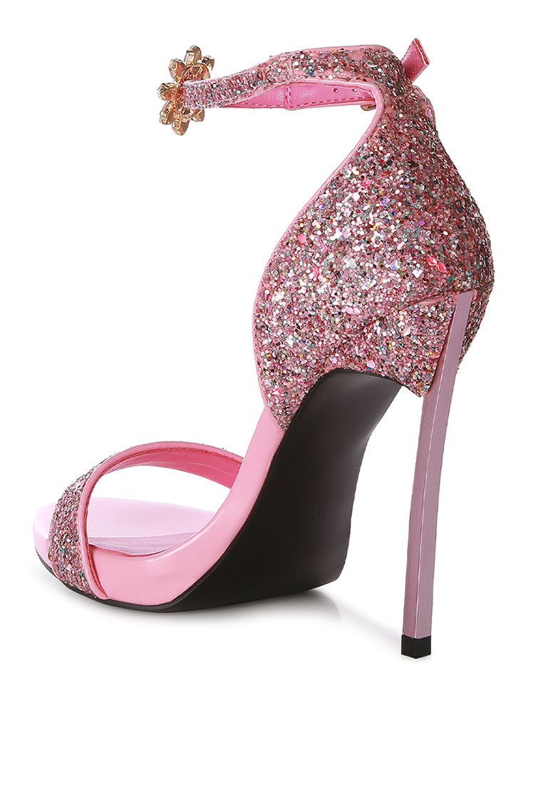 A pair of glamorous Straight Fire High Heel Glitter Stilettos featuring a glittery finish, floral jewel brooch, and a secure ankle strap.