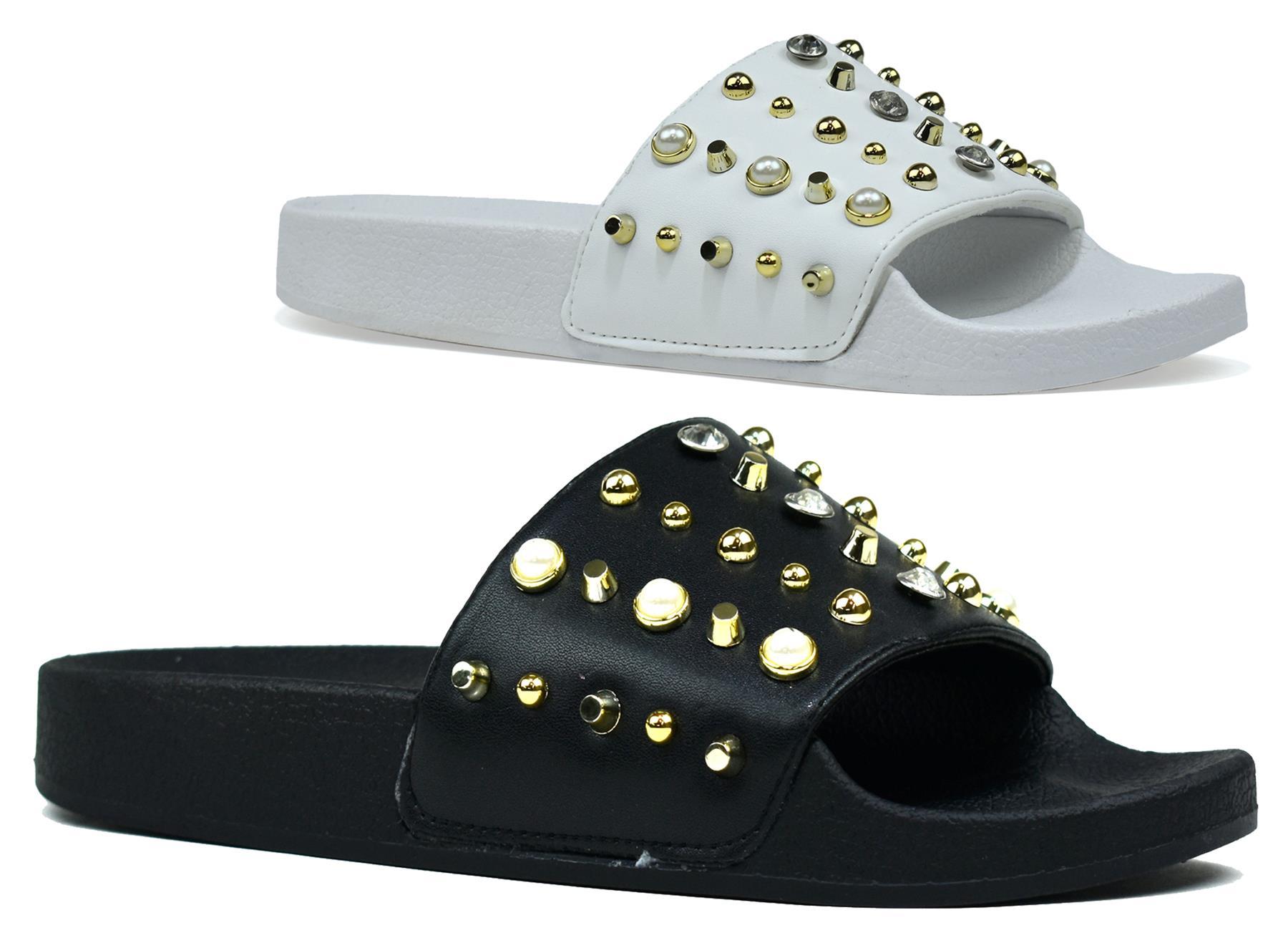 Stylish black and white studded sliders with gold accents, perfect for casual wear.