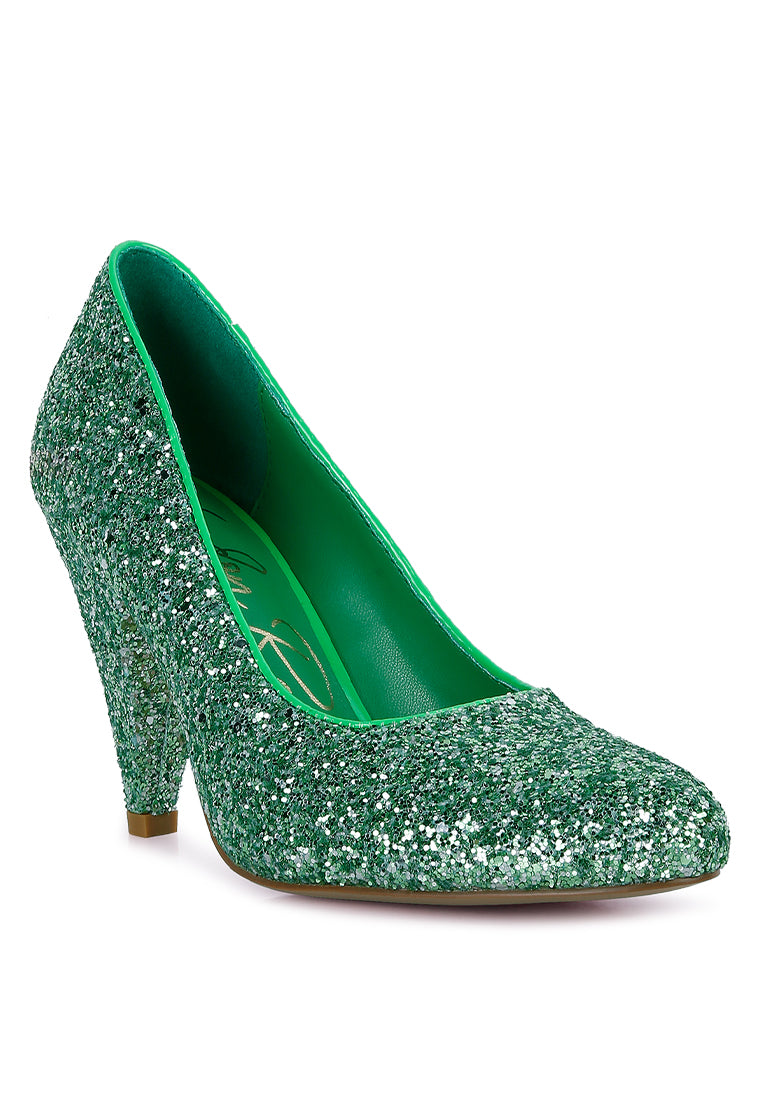 A pair of Sugar Plum Glitter Conical Heel Pumps showcasing a sparkling glitter exterior, conical heels, and a closed toe design, perfect for evening wear.