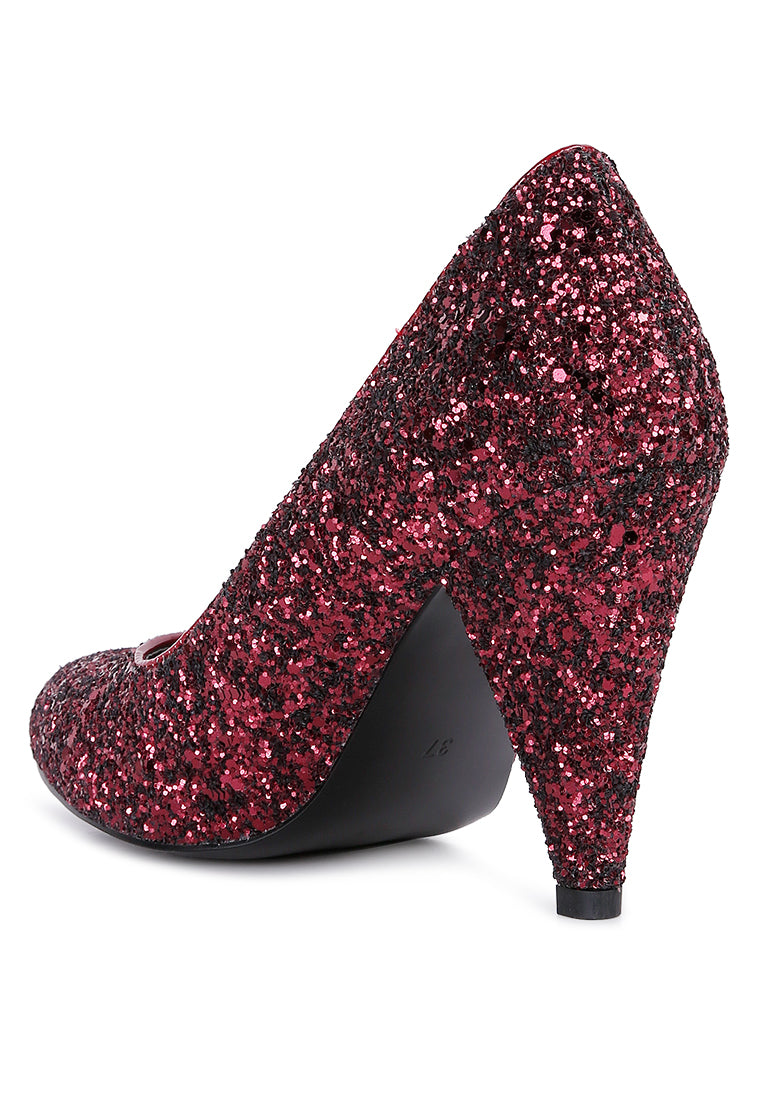 A pair of Sugar Plum Glitter Conical Heel Pumps showcasing a sparkling glitter exterior, conical heels, and a closed toe design, perfect for evening wear.