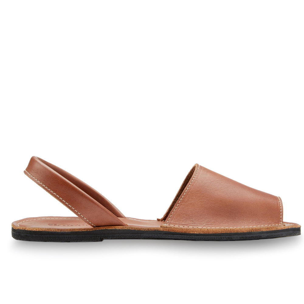 The Avarca women's flat leather sandal in black, showcasing its minimalist design and strappy heel.