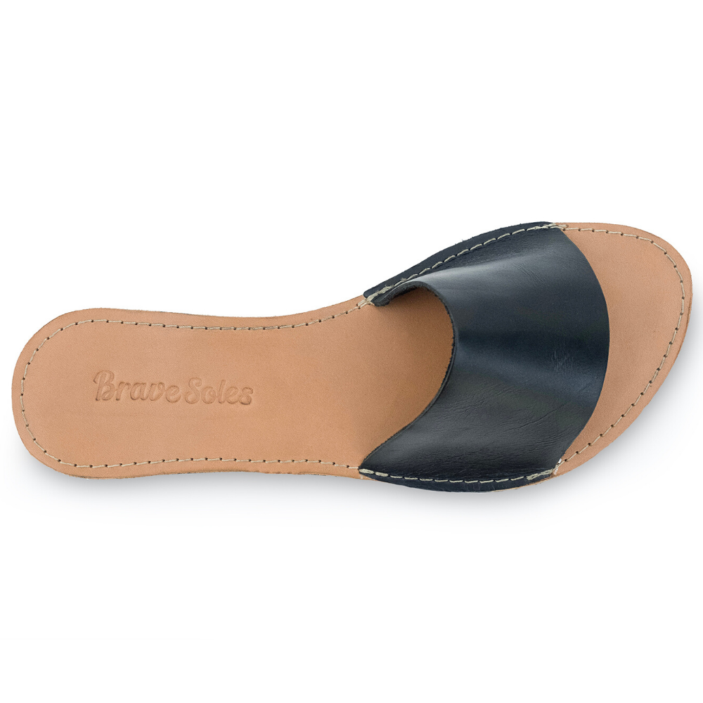 The Linda leather slide sandal, handcrafted with locally sourced leather and upcycled tire soles, showcasing its elegant design and comfort features.