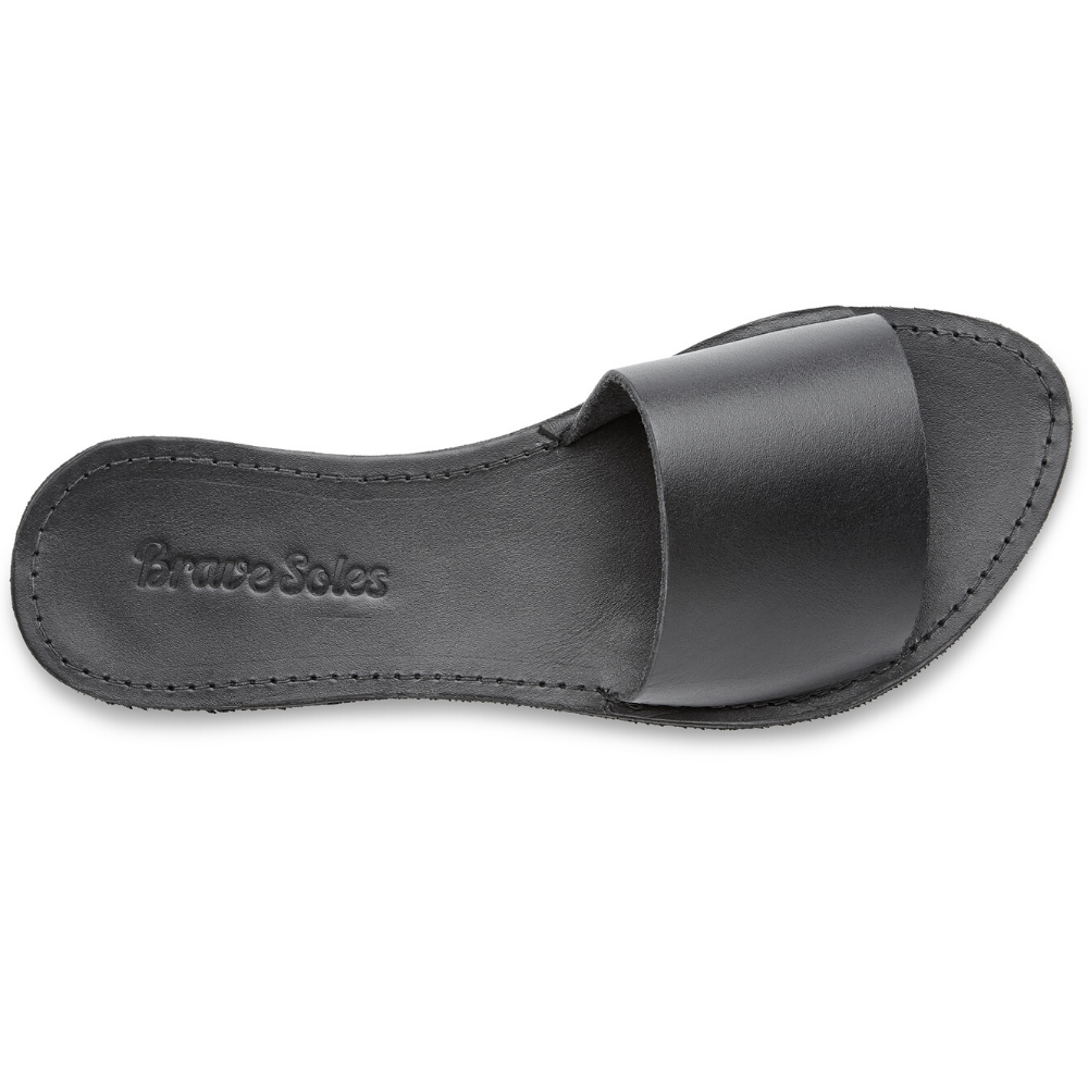 The Linda leather slide sandal, handcrafted with locally sourced leather and upcycled tire soles, showcasing its elegant design and comfort features.