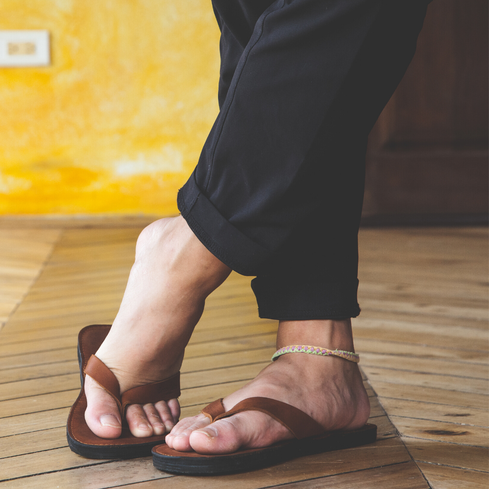 The Novio men's leather flip flops featuring a sleek design with handmade leather footbed and upcycled tire soles.