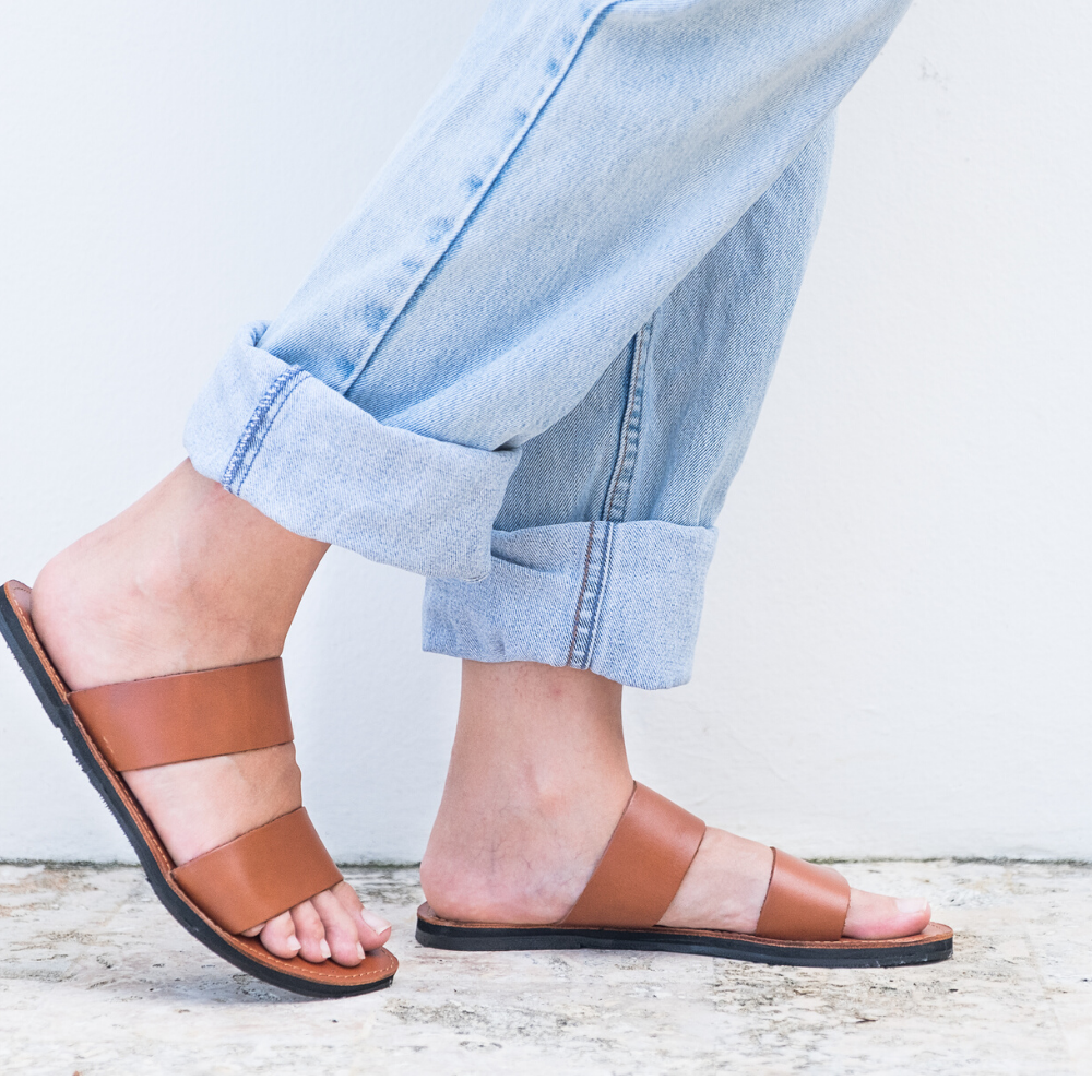 Stylish Ophelia Leather Slide Sandals in black and caramel, featuring minimalist design and eco-friendly upcycled tire soles.