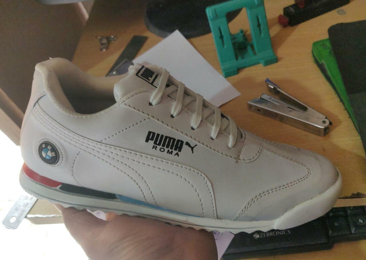 A pair of trendy white mens casual shoes by Puma, featuring a synthetic upper and PVC sole, designed for comfort and style.