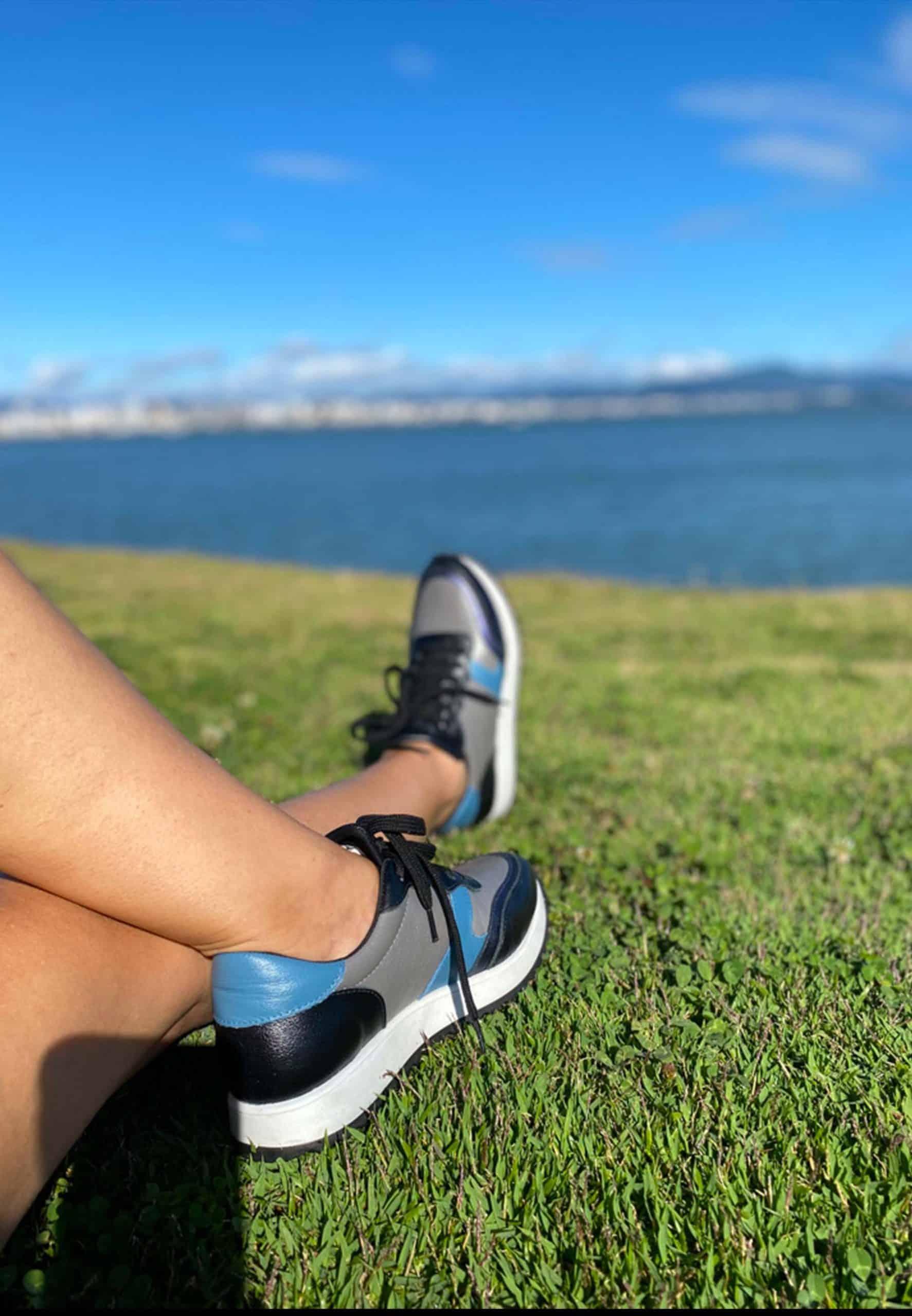 Stylish Mangará Buriri Walking Women's Sneakers in polished leather with grey, blue, and black accents, featuring a low-top silhouette and lace-up design.