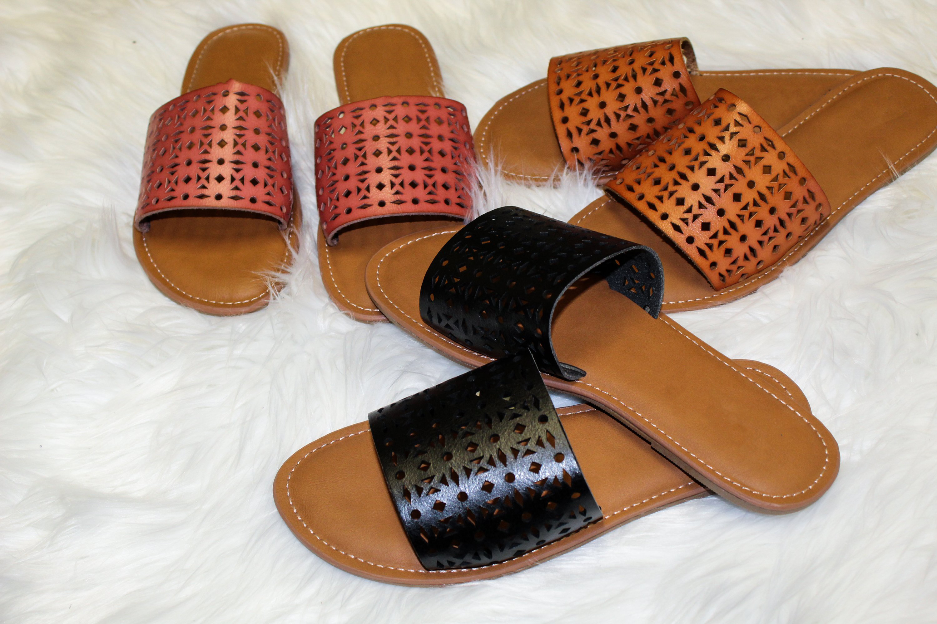 A pair of Women's Sandals Biarritz Brown featuring a cushioned sole and trendy perforated design, perfect for boho-style outfits.