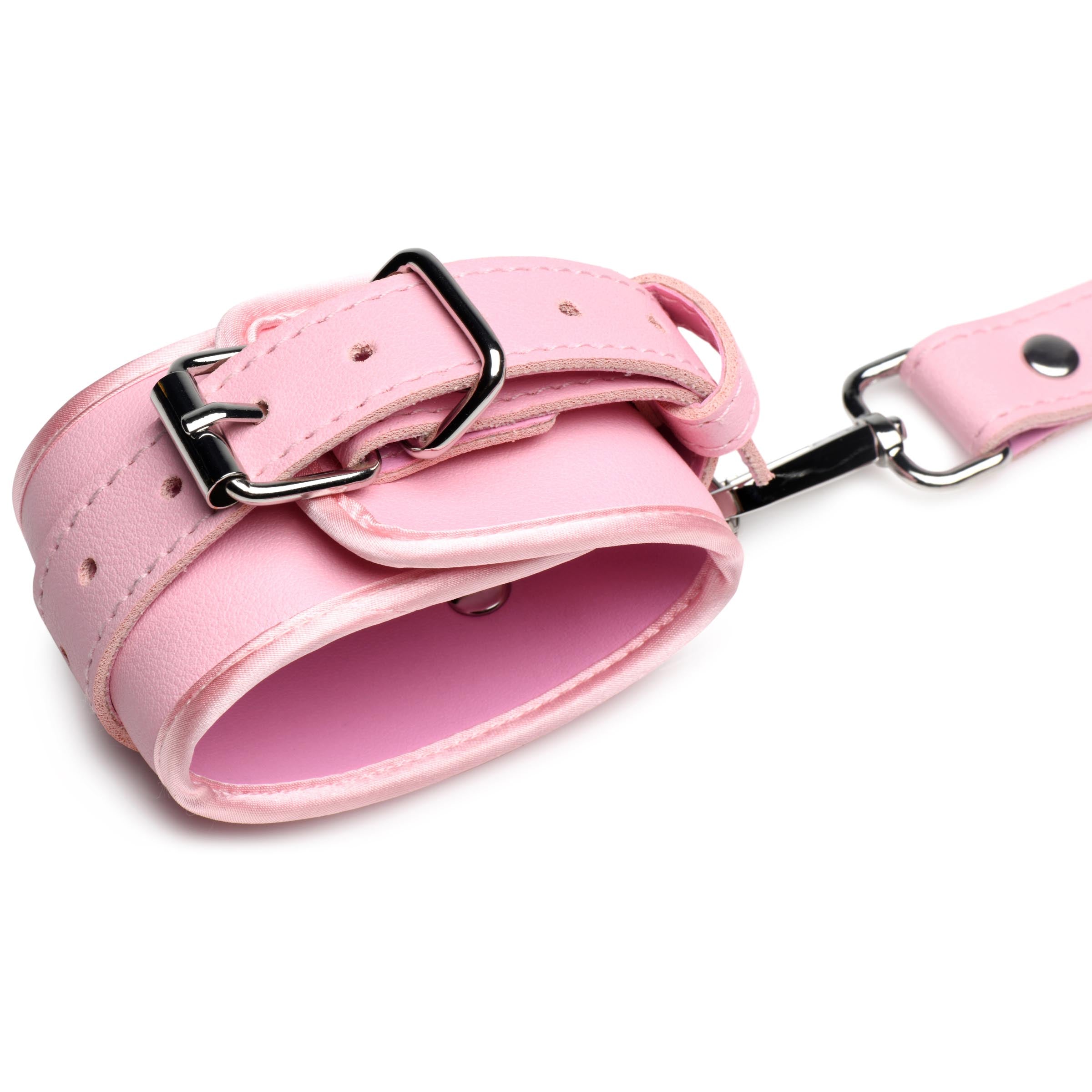 Pink bondage harness with bows, adjustable straps, and nickel-free metal buckles, designed for comfort and style.