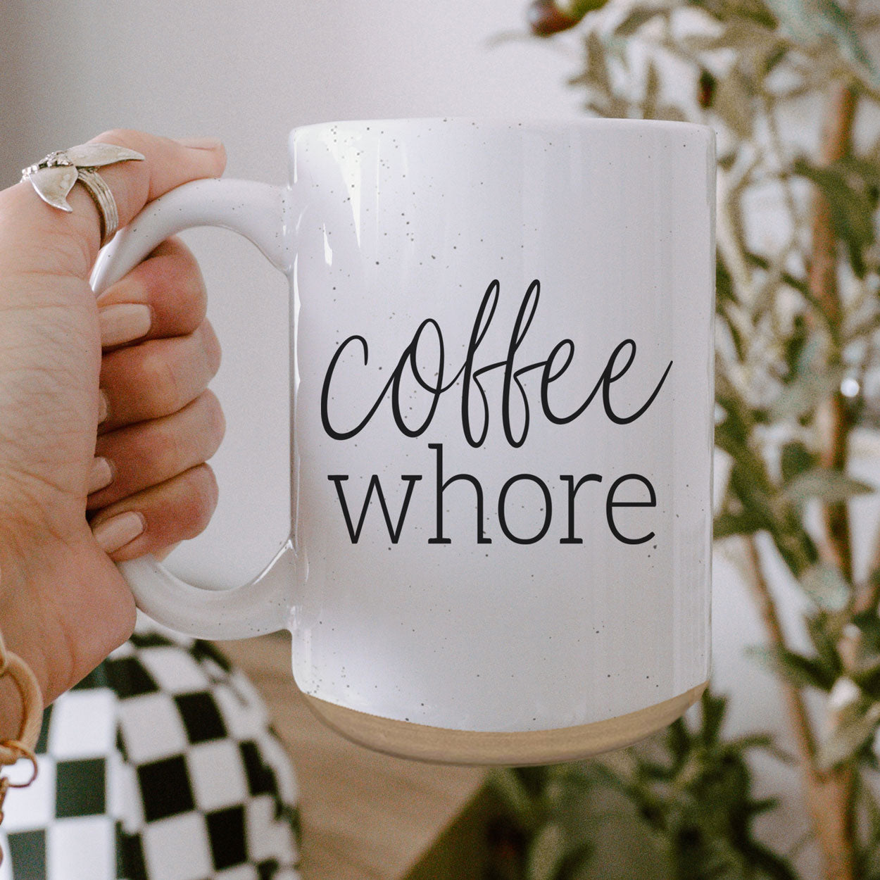 Coffee Whore Ceramic Mug with humorous graphic, off-white color with dark speckles, perfect for coffee lovers.