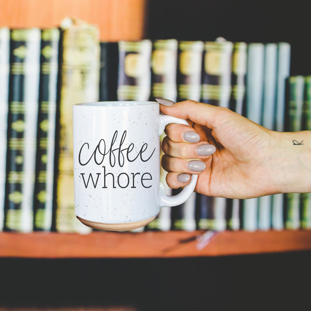 Coffee Whore Ceramic Mug with humorous graphic, off-white color with dark speckles, perfect for coffee lovers.