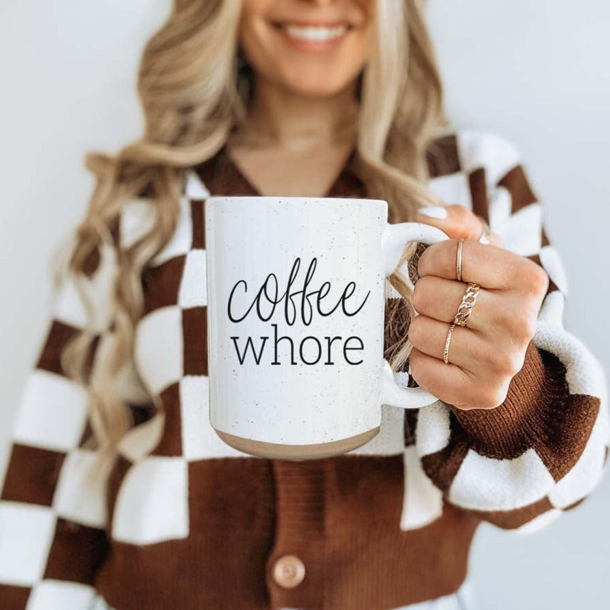 Coffee Whore Ceramic Mug with humorous graphic, off-white color with dark speckles, perfect for coffee lovers.