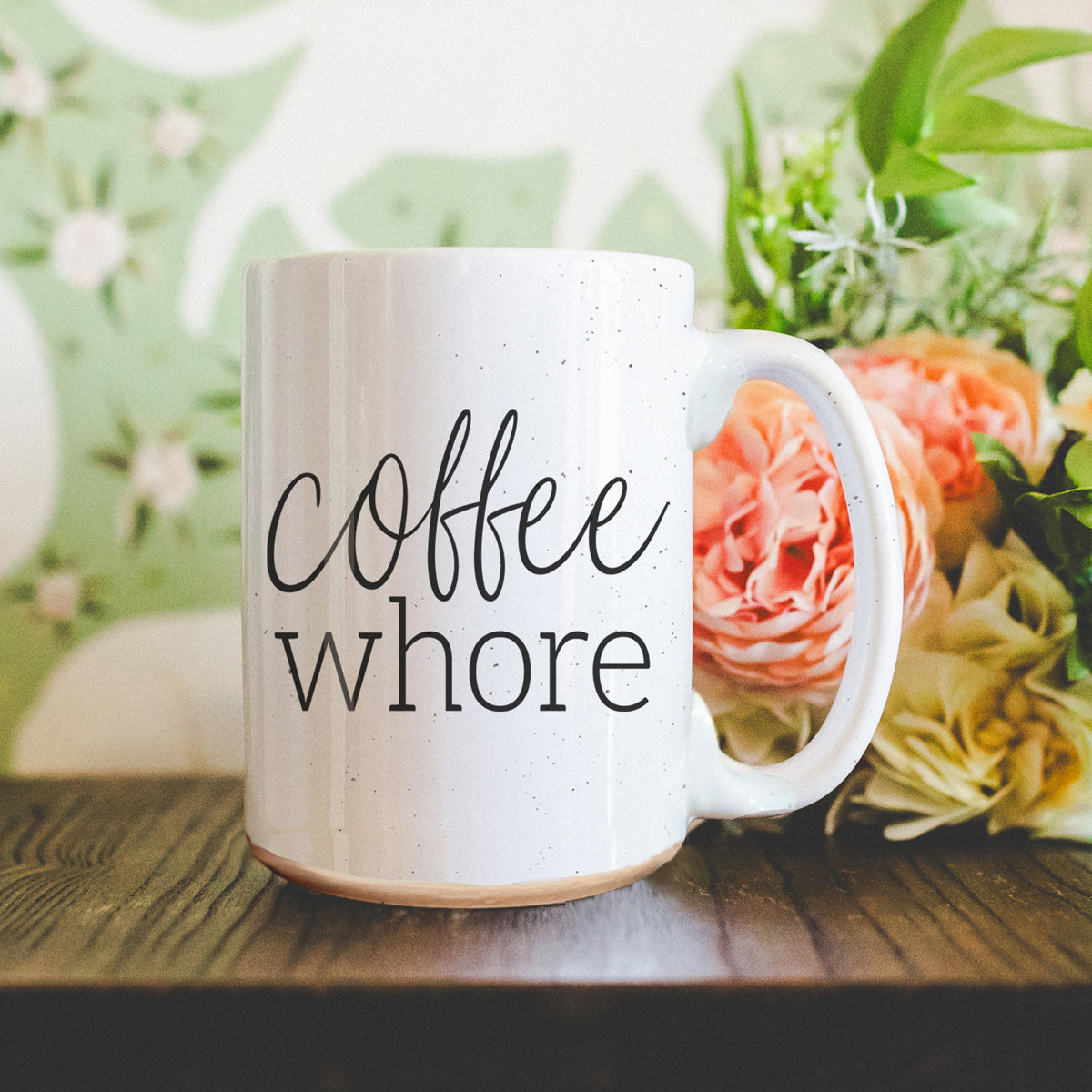 Coffee Whore Ceramic Mug with humorous graphic, off-white color with dark speckles, perfect for coffee lovers.