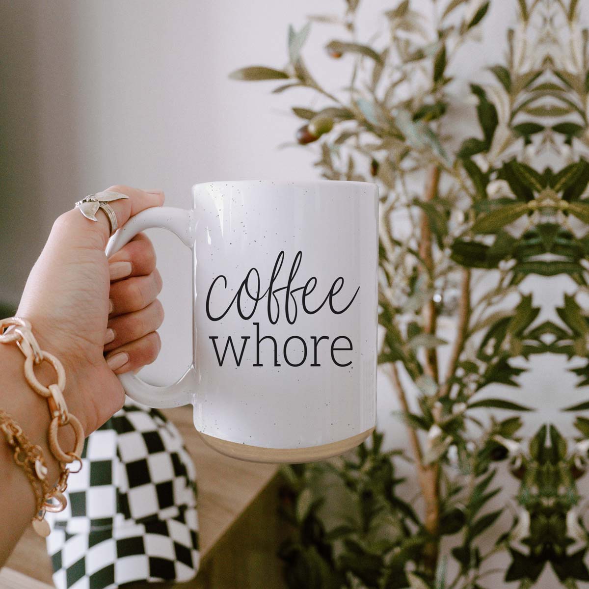 Coffee Whore Ceramic Mug with humorous graphic, off-white color with dark speckles, perfect for coffee lovers.