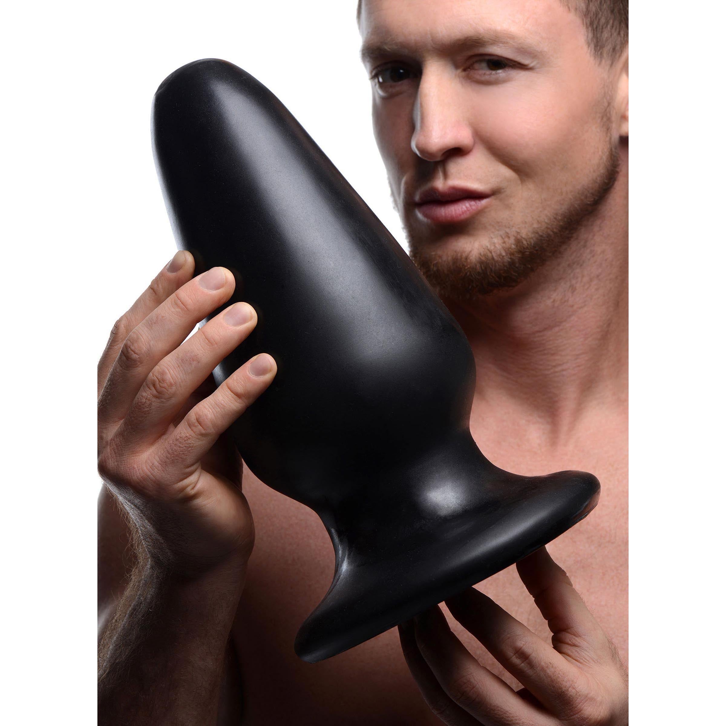 Gigantor XXXL Tapered Butt Plug in black PVC, showcasing its large size and tapered design for advanced anal play.