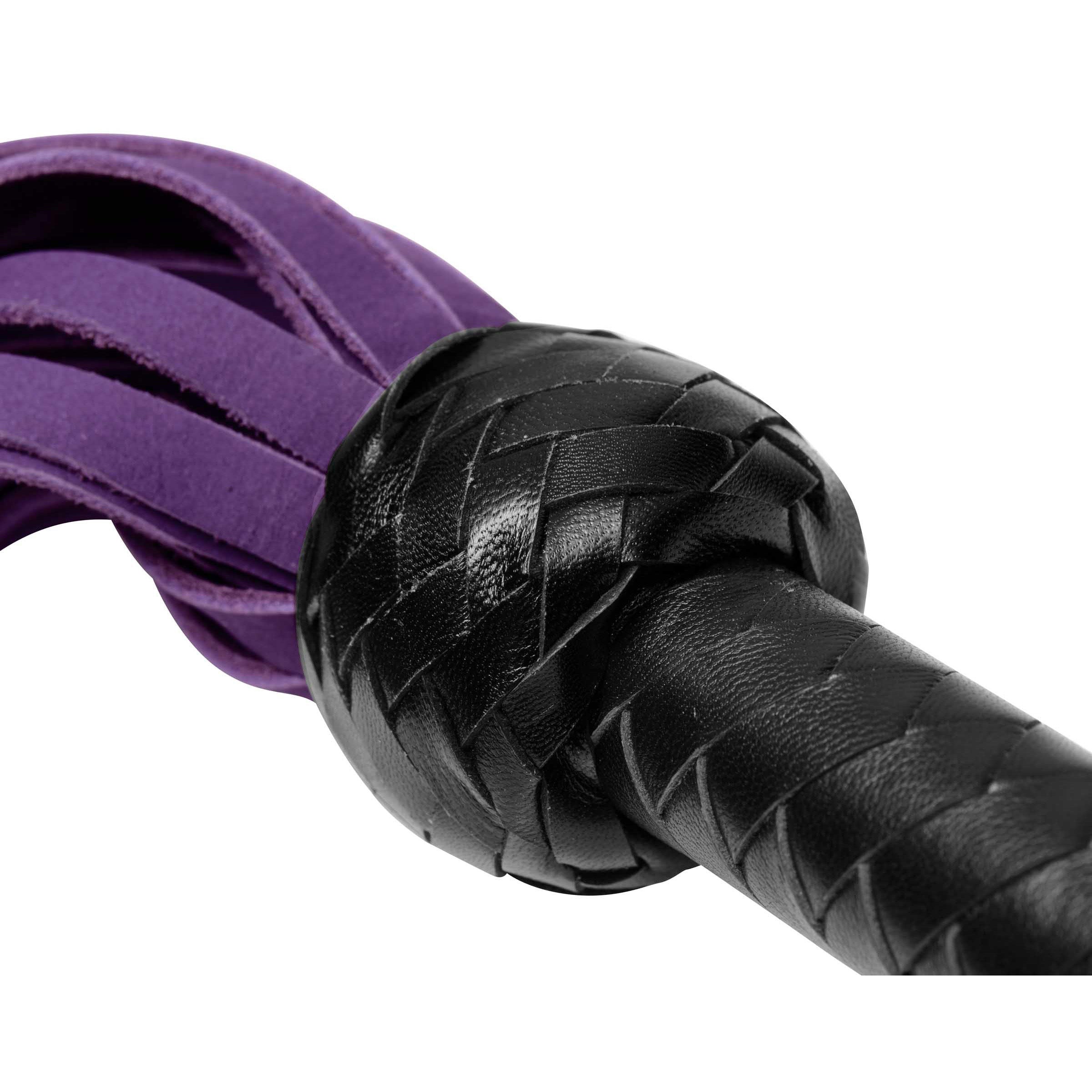 A Nubuck Flogger featuring purple-dyed falls and a black leather handle, showcasing its soft texture and elegant design.