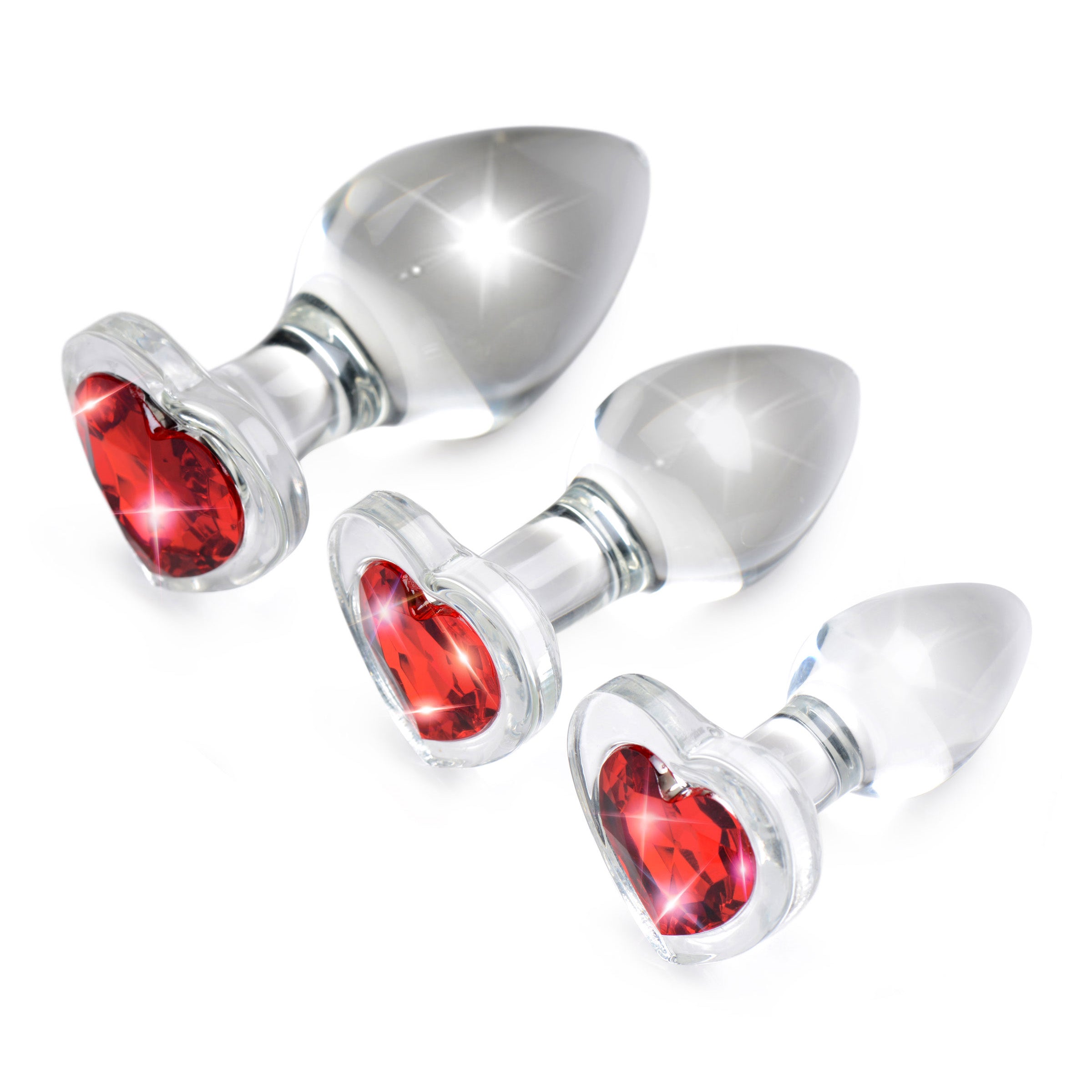 A set of three graduated red heart-shaped glass anal plugs, showcasing their smooth surface and tapered design for easy insertion.