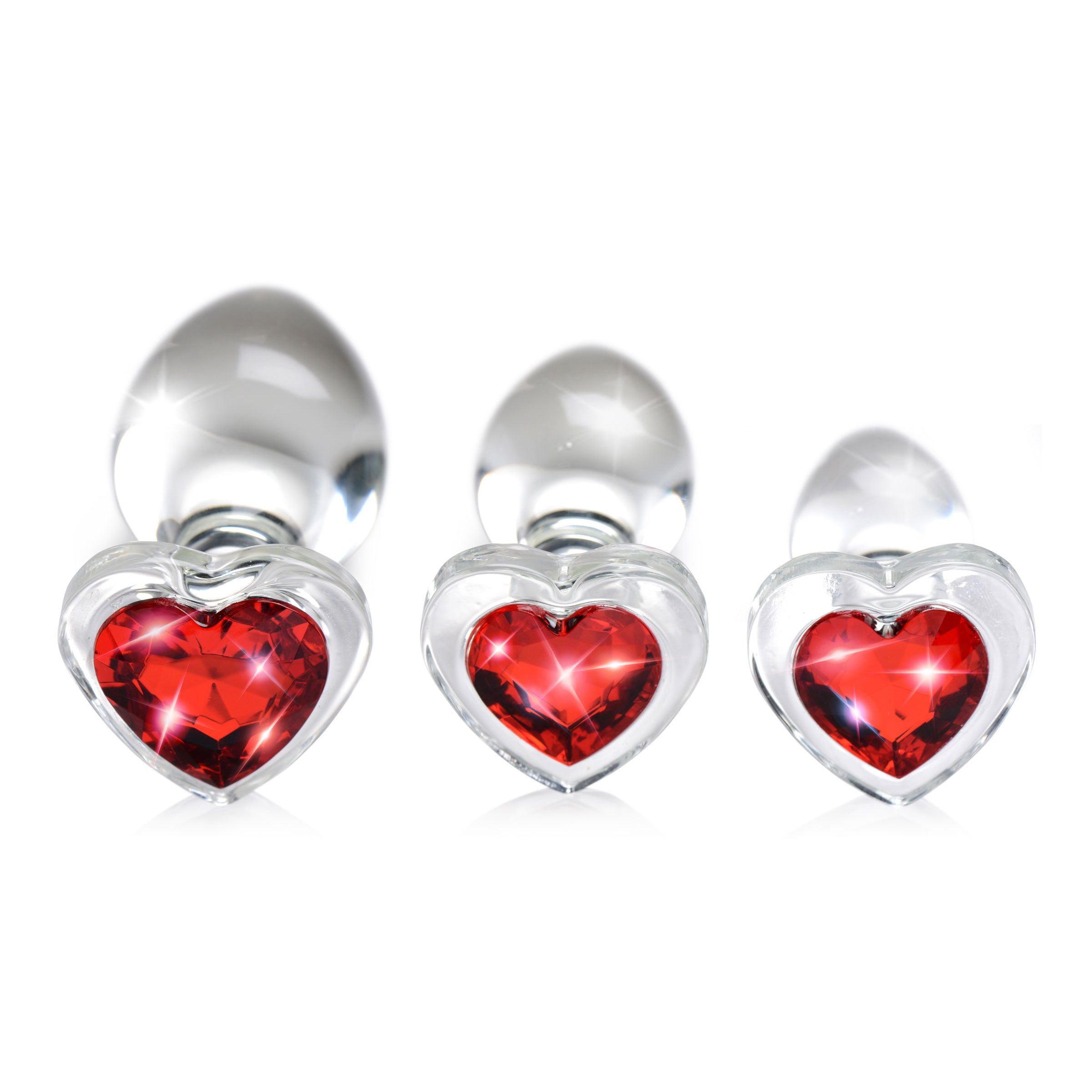 A set of three graduated red heart-shaped glass anal plugs, showcasing their smooth surface and tapered design for easy insertion.