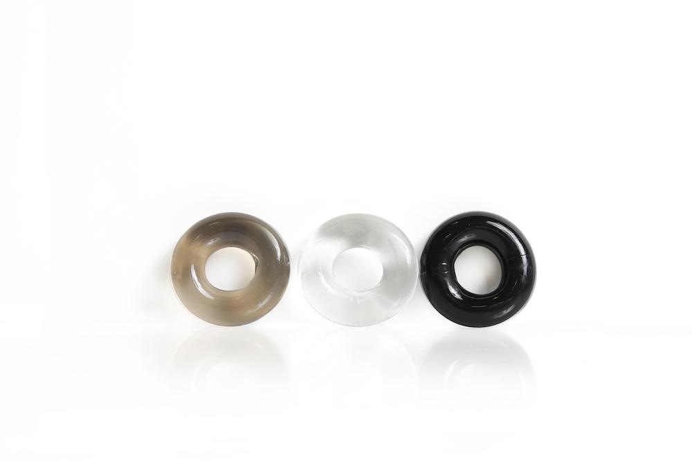 Triple Play Cock Ring set featuring three rings in black, clear, and smoke colors, made from stretchy TPE for comfort and support.