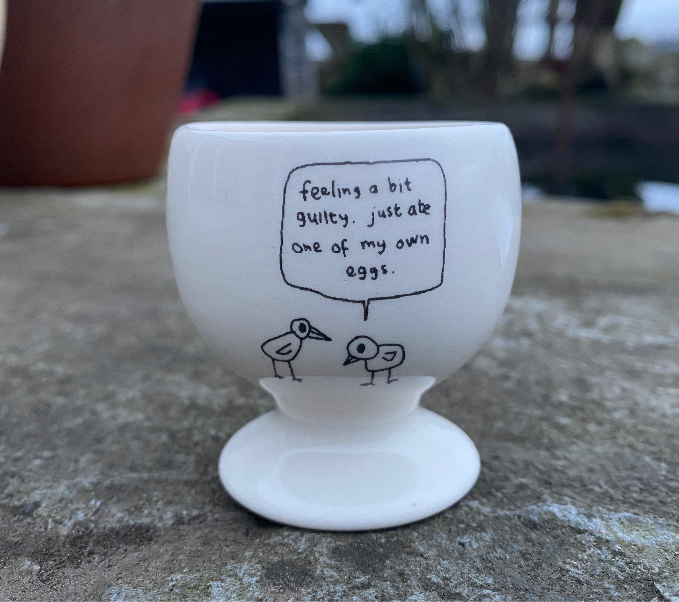 Ate My Own Egg Egg Cup made of high-quality ceramic with a whimsical design, perfect for serving soft-boiled eggs.