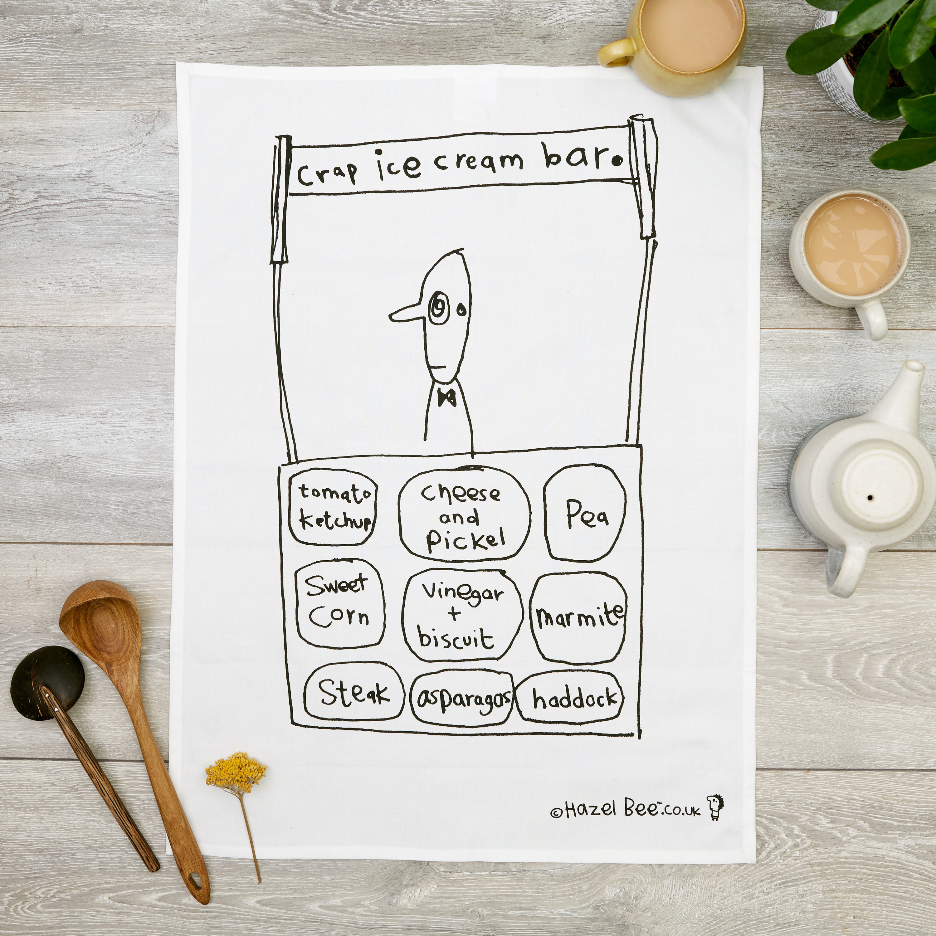 Crap Ice-cream Tea Towel made from organic cotton, featuring a humorous design in black ink, with a hanging loop for easy storage.