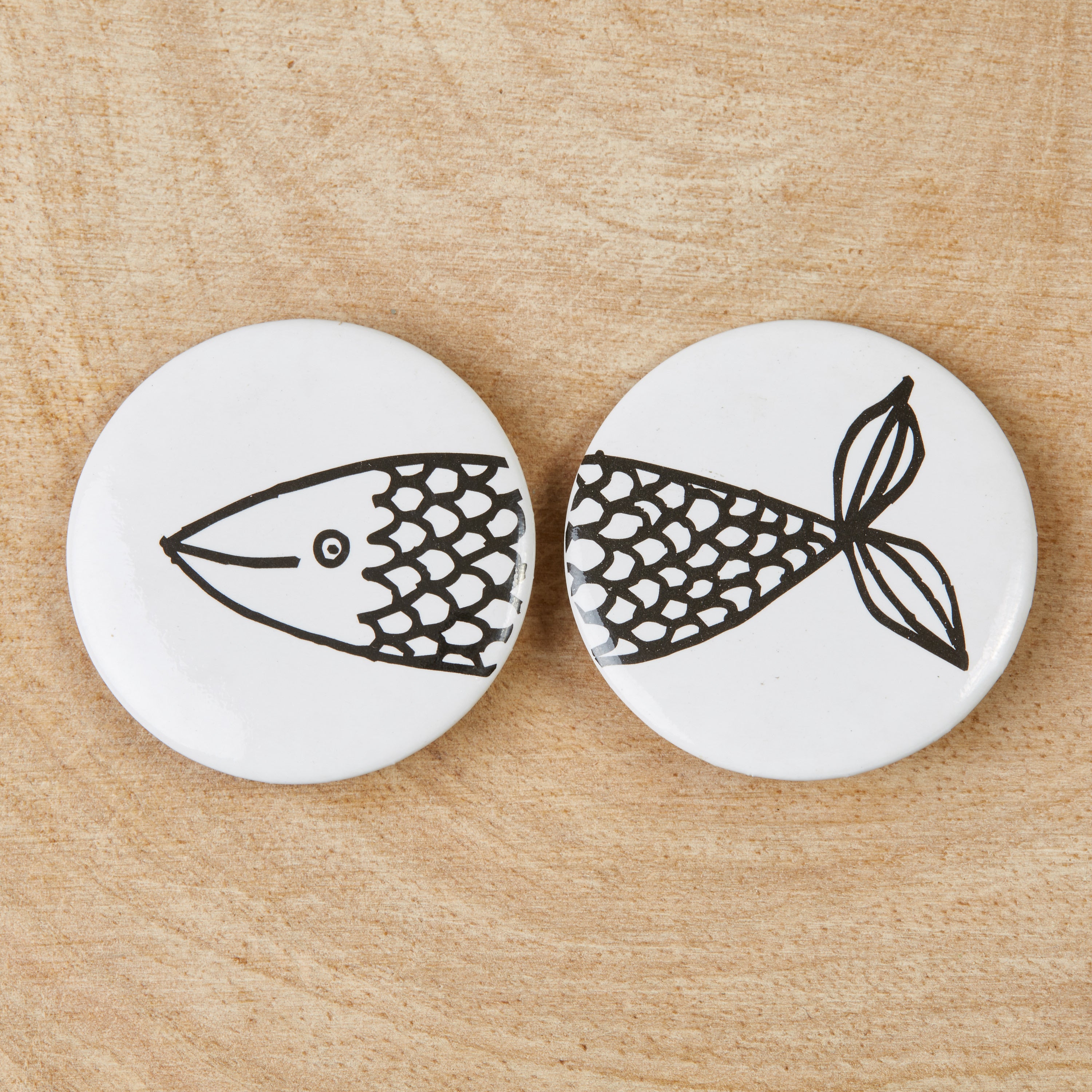 A set of eco-friendly Friendship Fish badges featuring a black design on a white background, measuring 38mm in width.