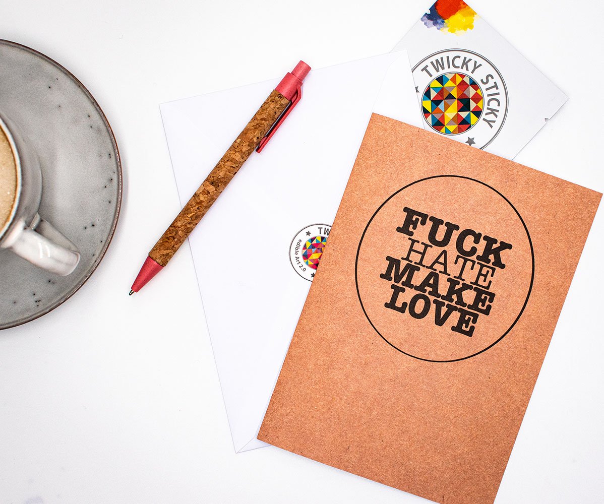 A beautifully arranged gift set featuring a Twicky Sticky with Bourbon Vanilla flavor, a greeting card, and a stylish envelope, all promoting love and tolerance.