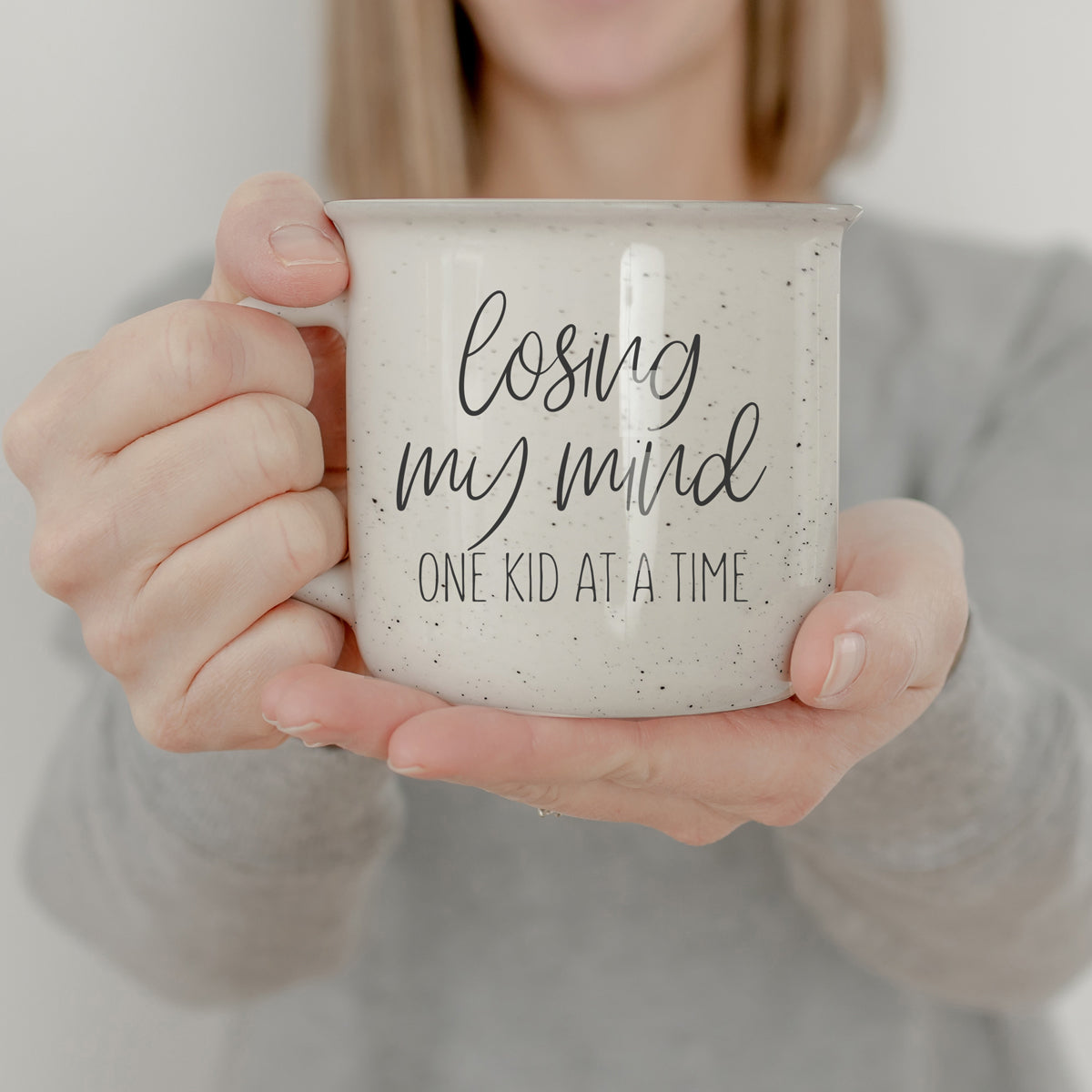 A 14.5oz ceramic campfire style coffee mug with a humorous quote for parents, featuring a light ivory color with speckles and black lettering.