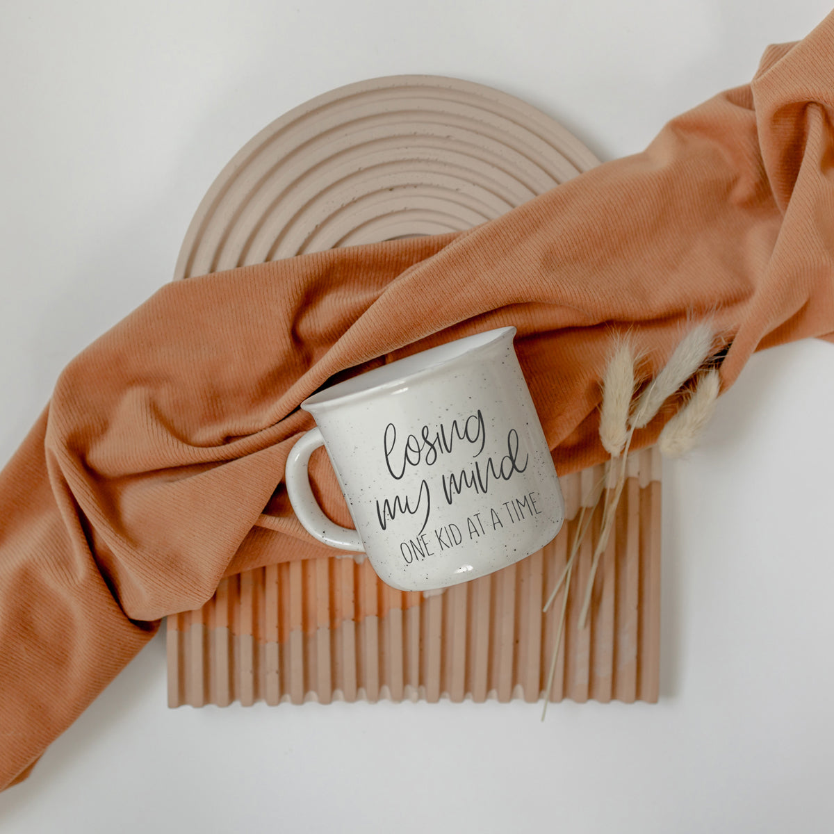 A 14.5oz ceramic campfire style coffee mug with a humorous quote for parents, featuring a light ivory color with speckles and black lettering.