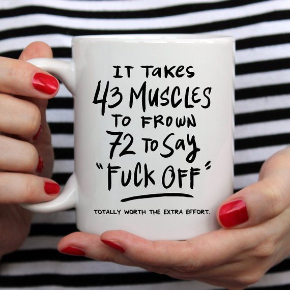 A humorous coffee mug featuring the phrase 'It Takes 43 Muscles To Frown, 72 To Say 'Fuck Off'.' Perfect for coffee lovers.