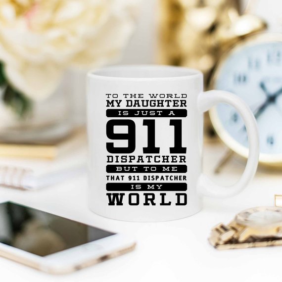 A white ceramic mug featuring a vibrant design celebrating 911 dispatchers, printed on both sides.