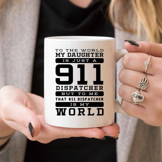 A white ceramic mug featuring a vibrant design celebrating 911 dispatchers, printed on both sides.