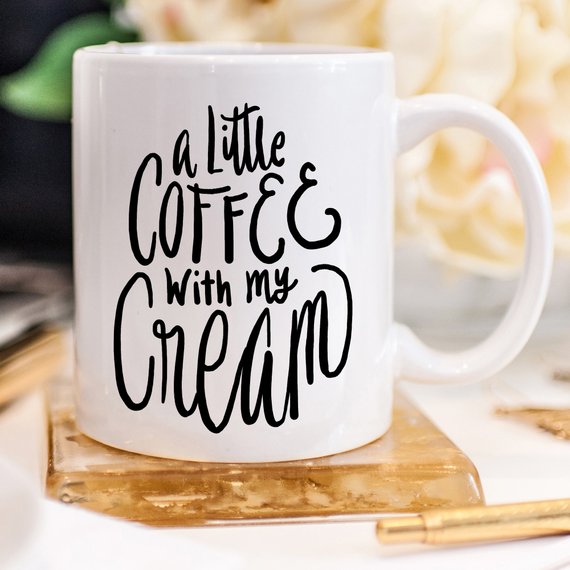 A humorous coffee mug with the phrase 'A Little Coffee With My Cream' printed on it, showcasing a fun design perfect for coffee lovers.