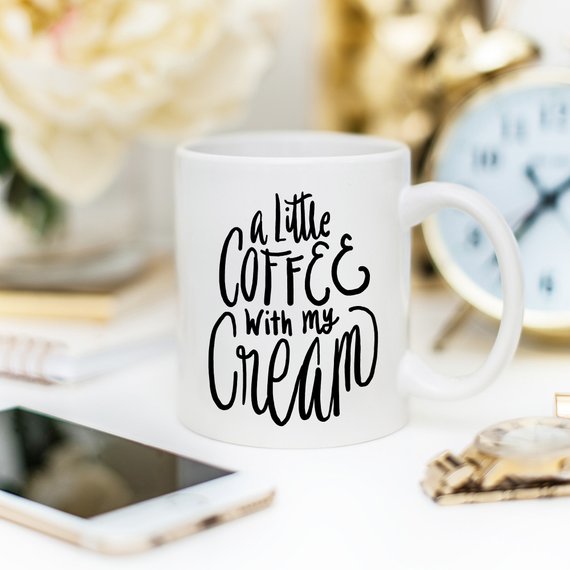 A humorous coffee mug with the phrase 'A Little Coffee With My Cream' printed on it, showcasing a fun design perfect for coffee lovers.